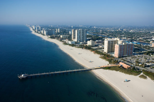 Aerial view of waterfront buildings and pier over ocean at Pompano Beach, Flordia.