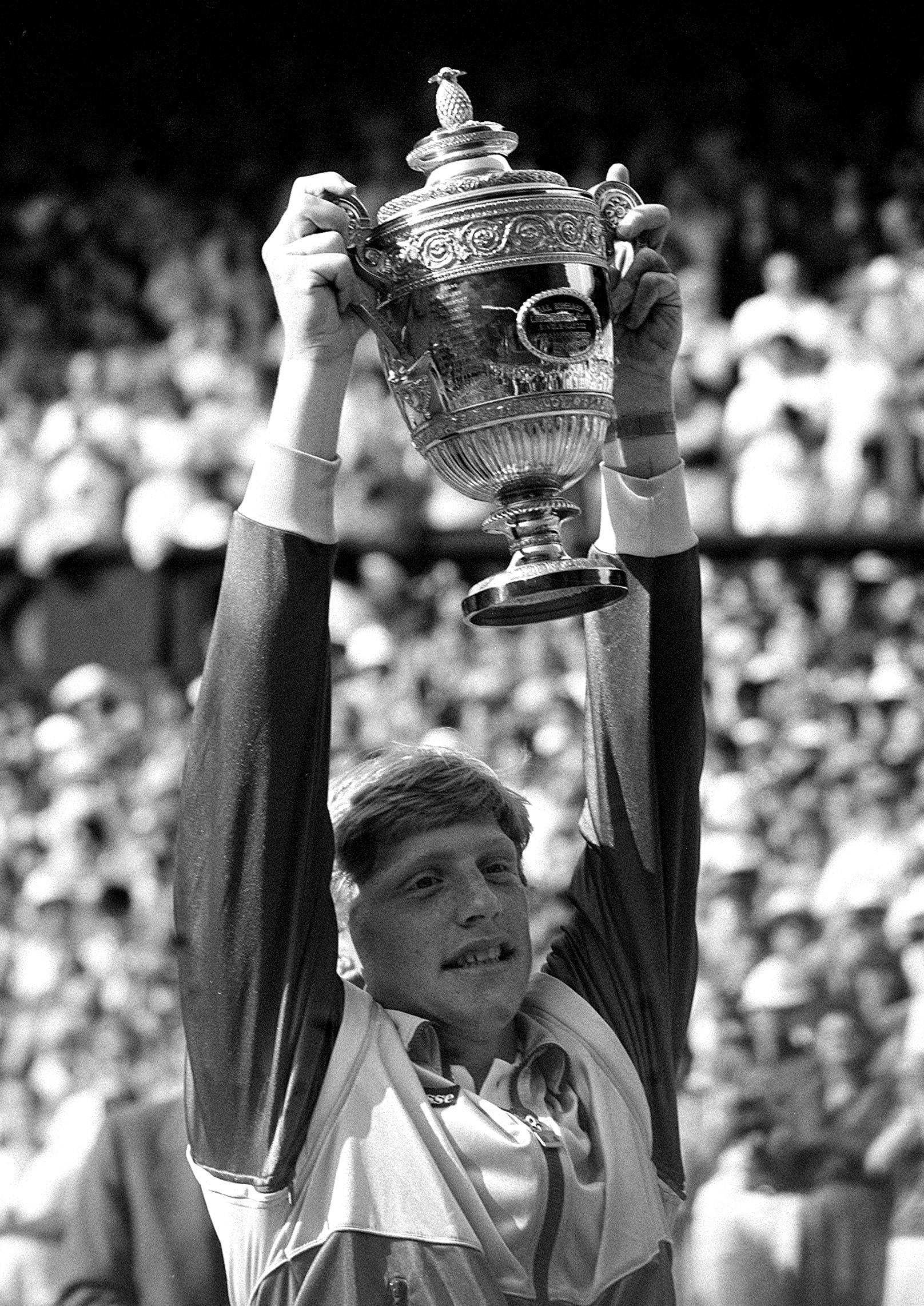 Boris Becker holds aloft his trophy (PA)