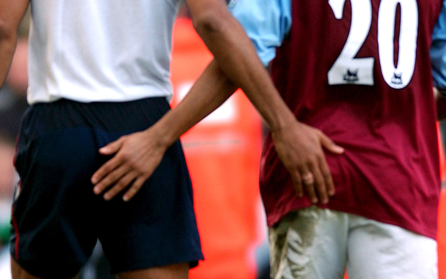Footballers with hands on glutes