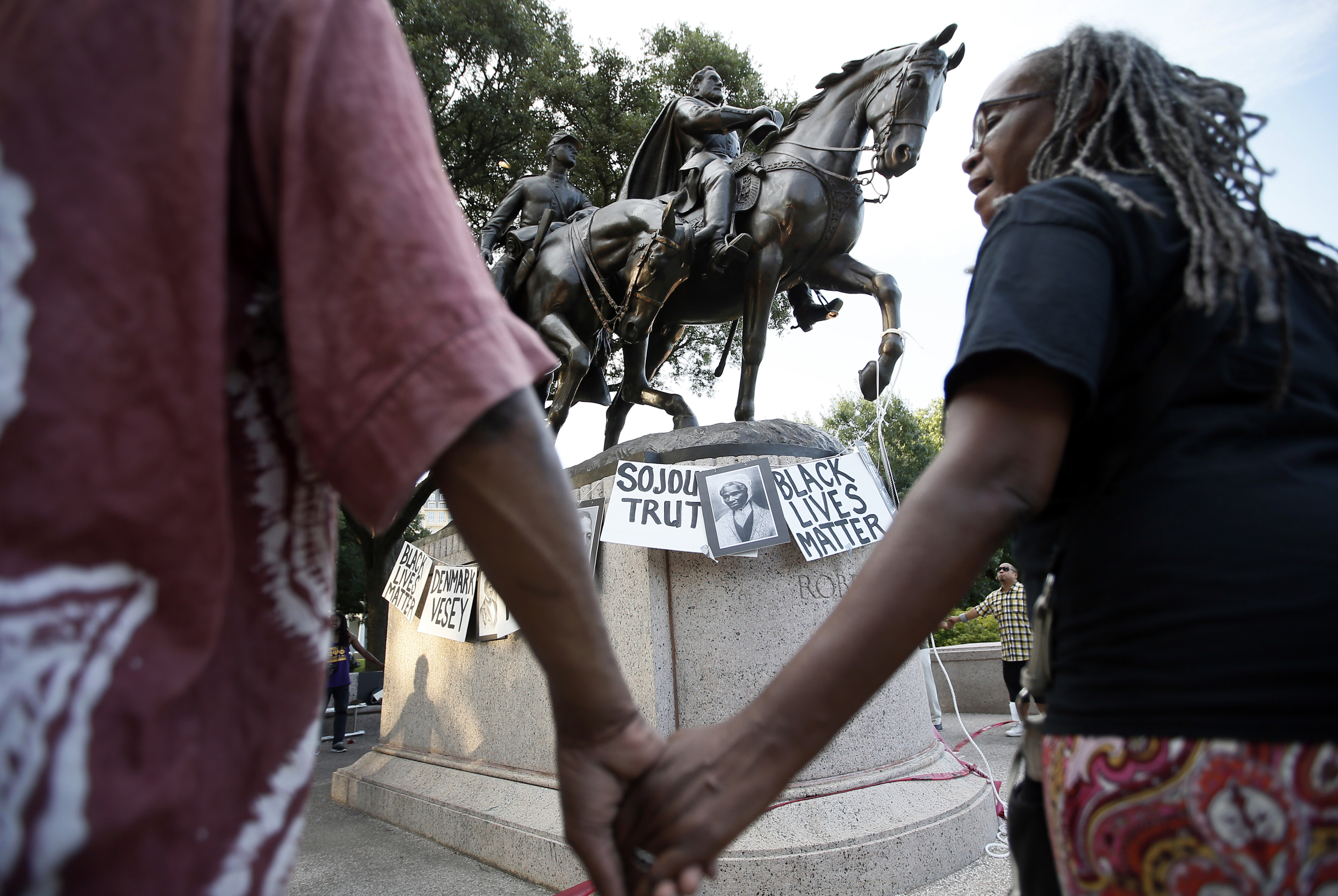 Activists gather around a statue of Lee