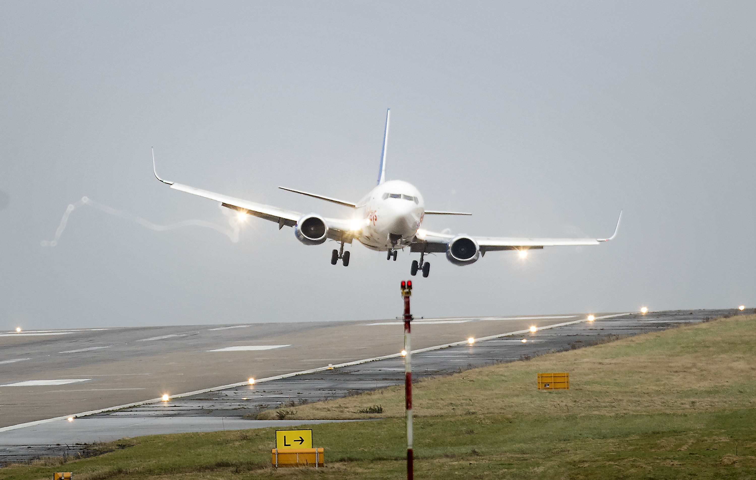 A plane lands at a jaunty angle