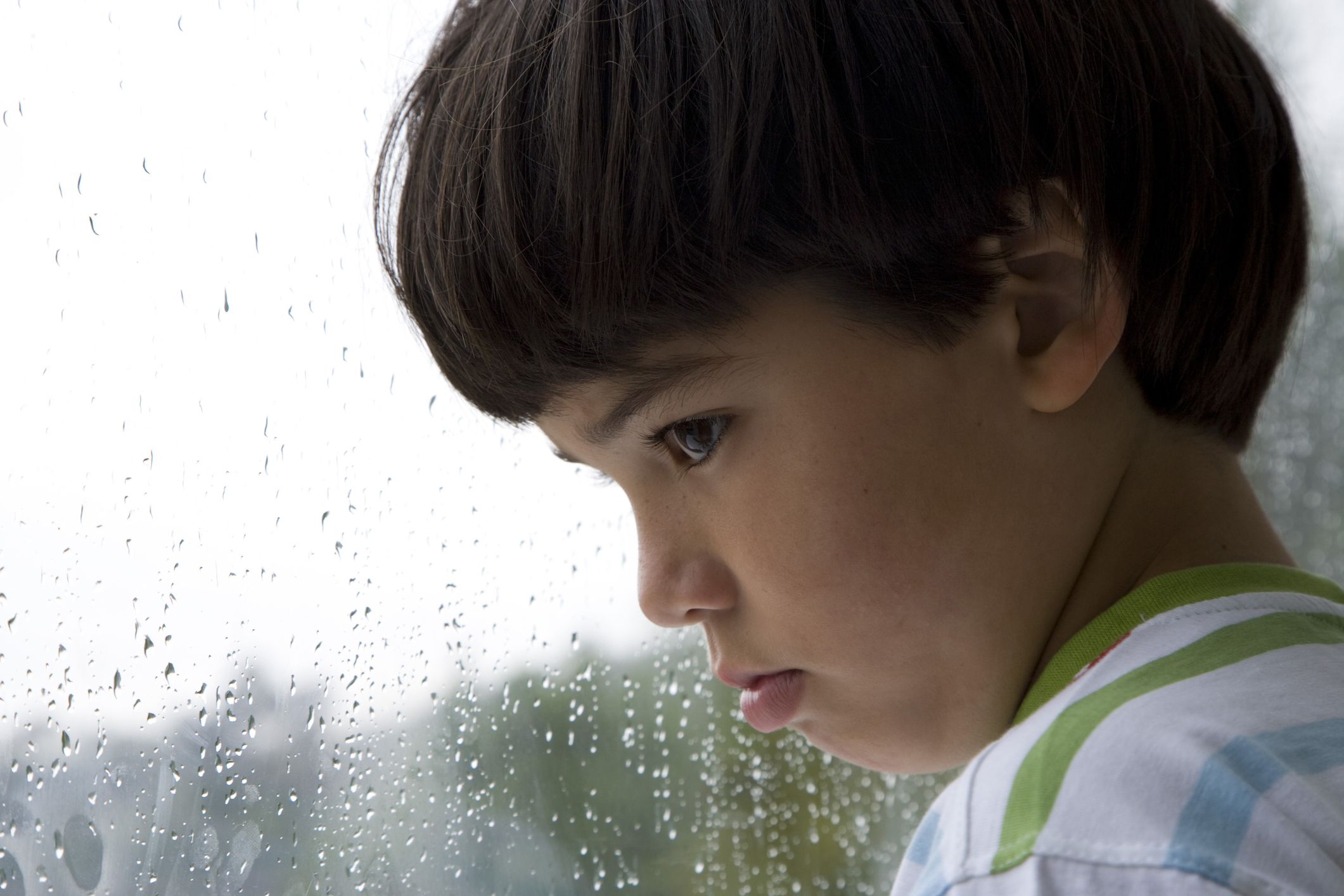 Close-up of a boy looking out a window on a rainy day (Thinkstock/PA)