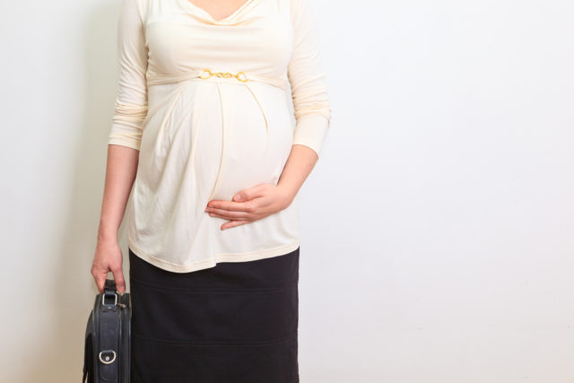 A pregnant businesswoman standing with briefcase (Thinkstock/PA)
