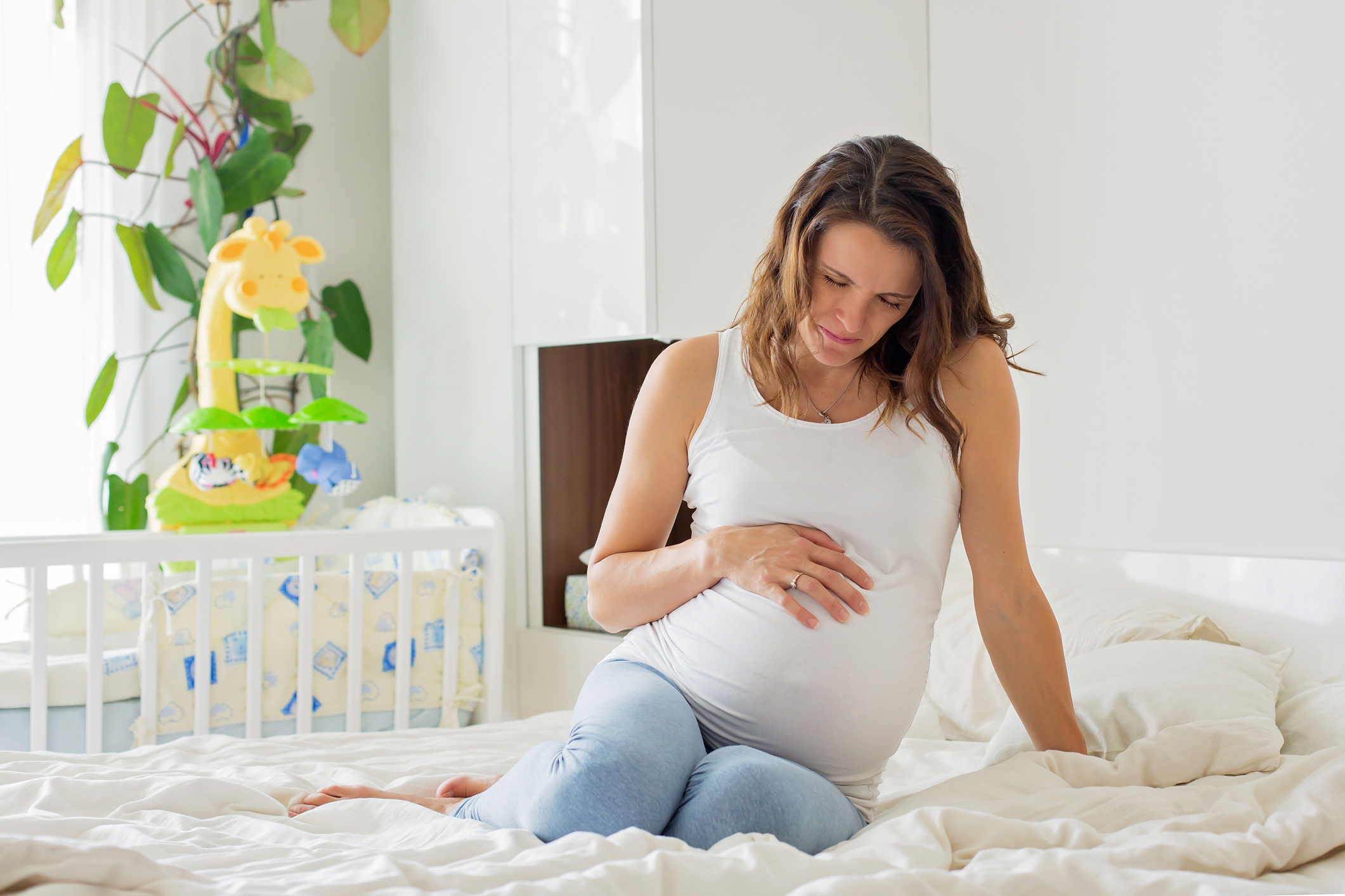 A pregnant woman endures a contraction in her bedroom at home (Thinkstock/PA)