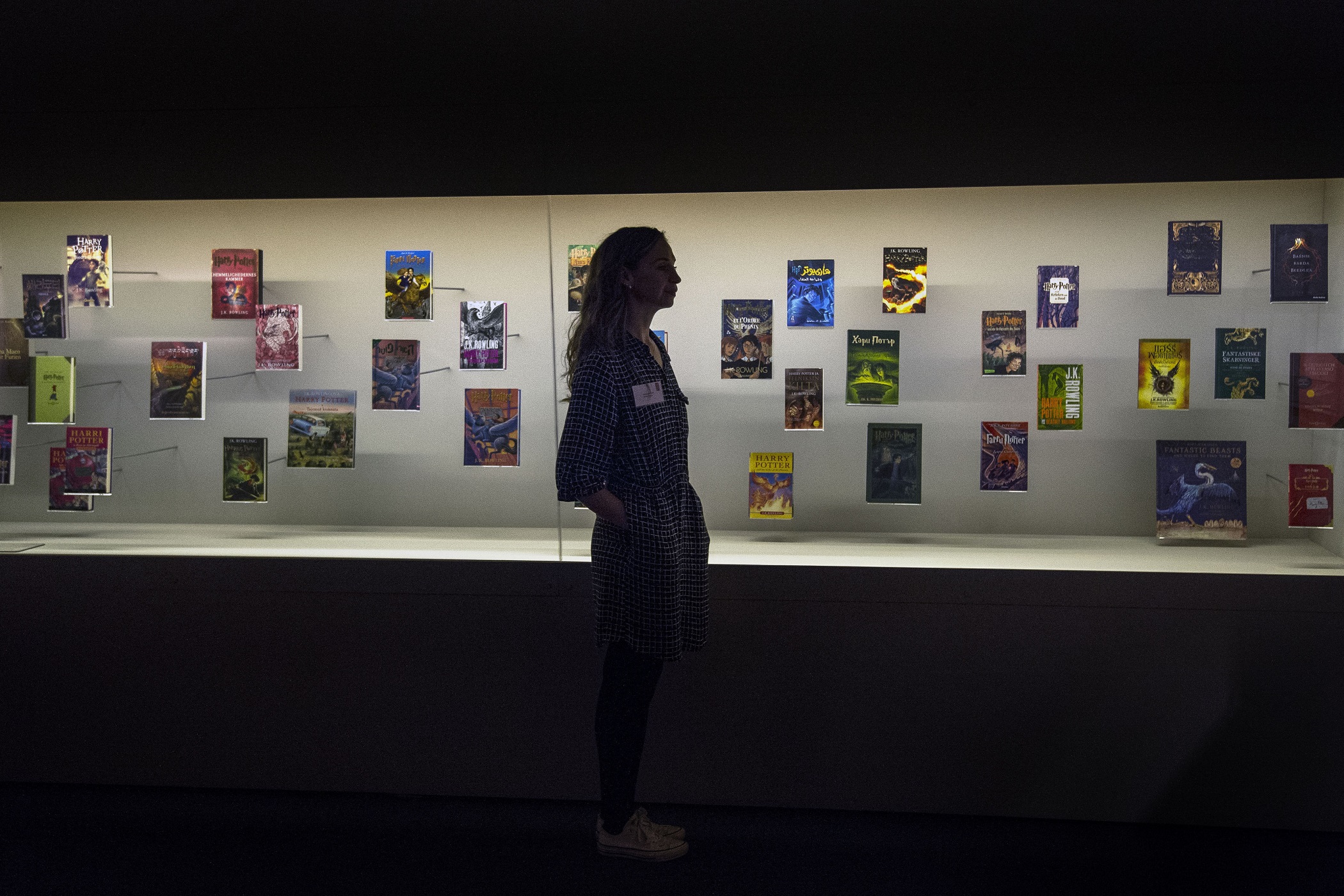 A visitor walks past a display of foreign language editions of the Harry Potter books at the British Library (Victoria Jones/PA)