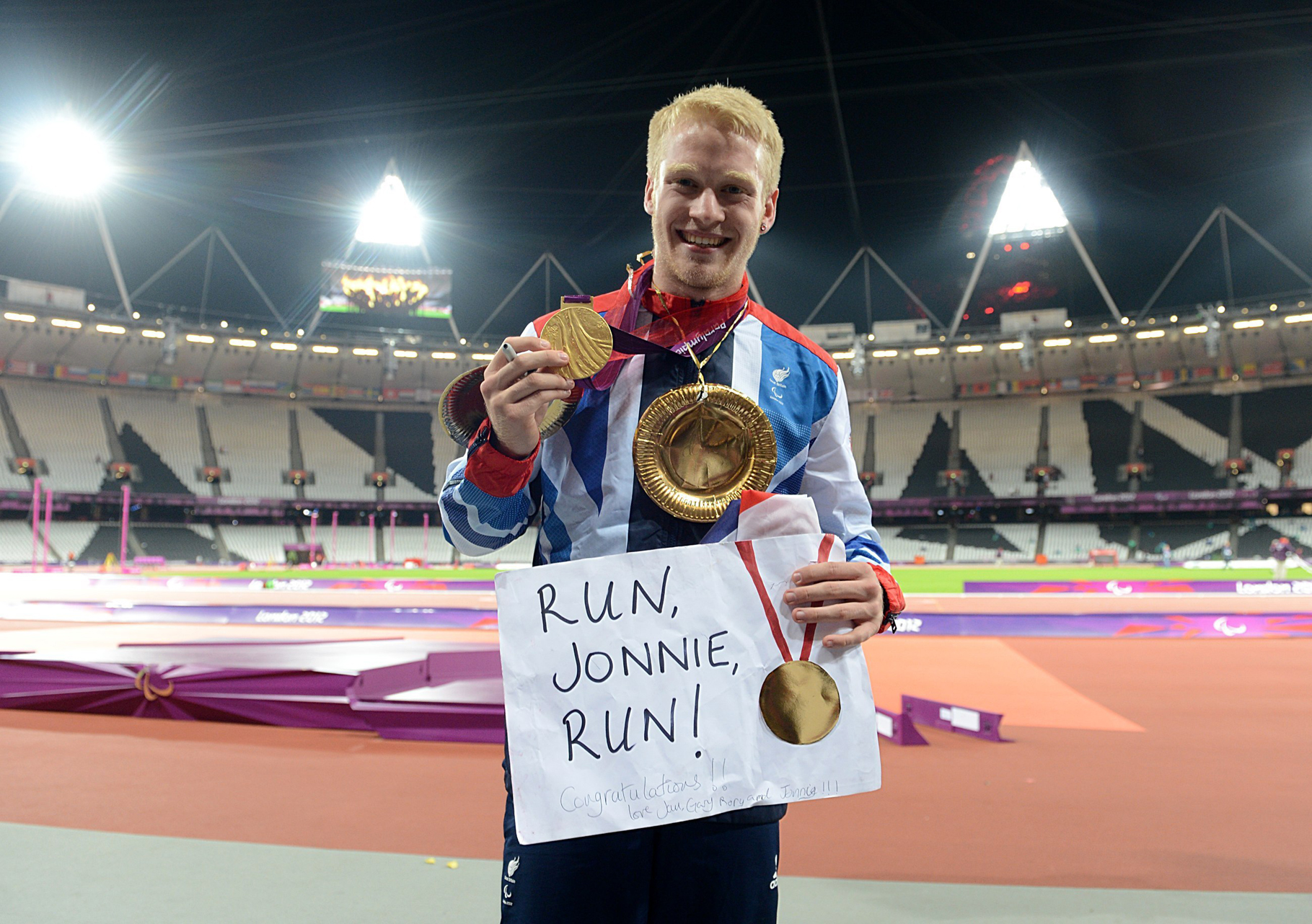 Jonnie Peacock celebrates with his gold medal in the Men's 100m - T44 Final, during the Paralympic Games in London, 2012. (Anthony Devlin/PA)