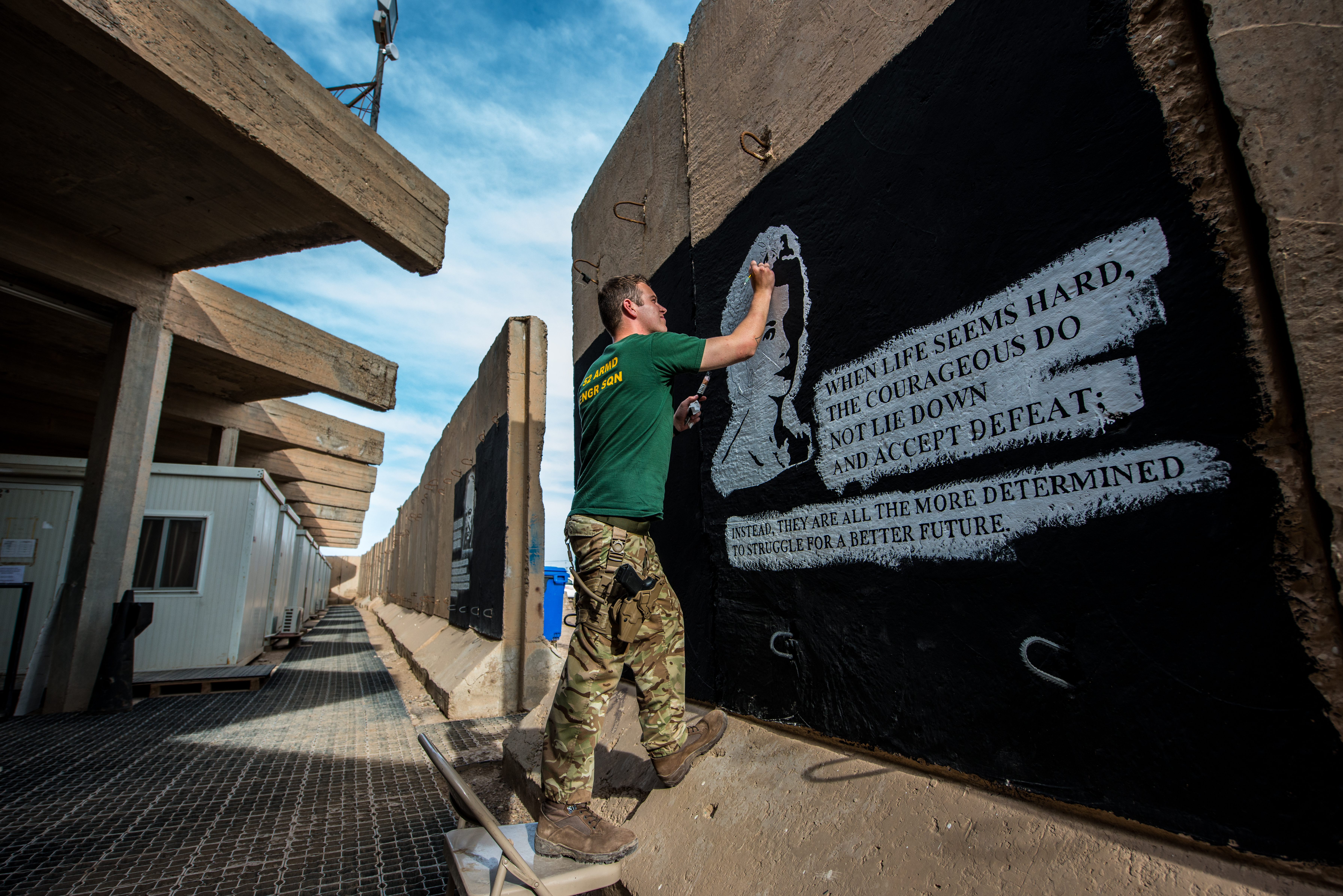 Sapper Adam Williams painting a blast wall in Iraq (Nick Johns)