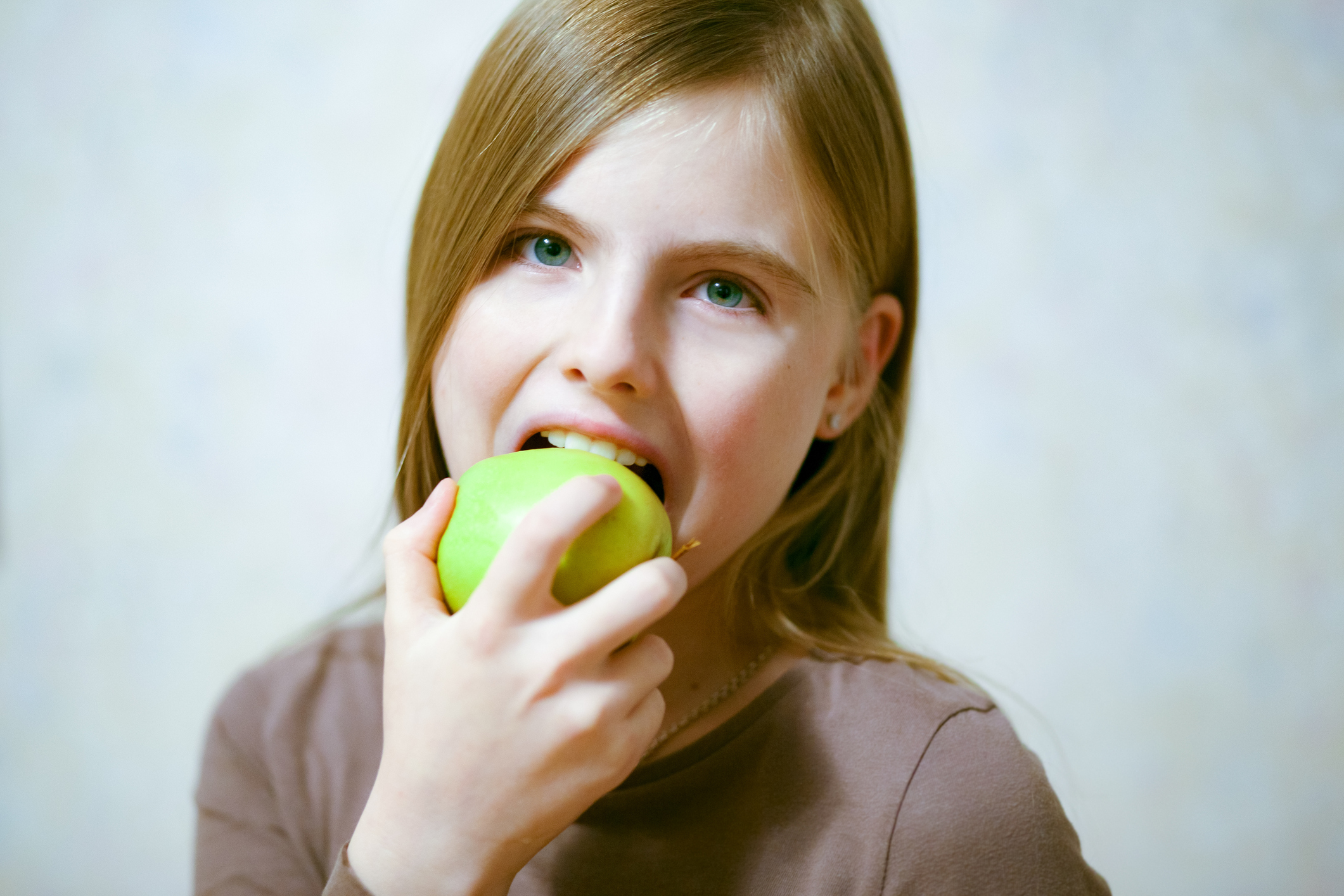 Young girl eating a green apple (Thinkstock/PA)