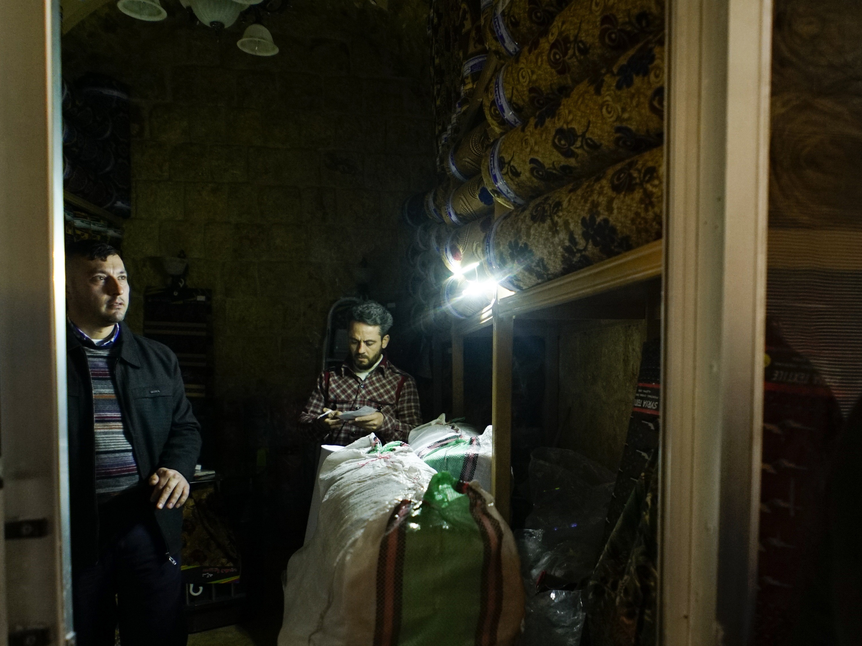 Men work inside a shop in Aleppo's old market (Mstyslav Chernov/AP)