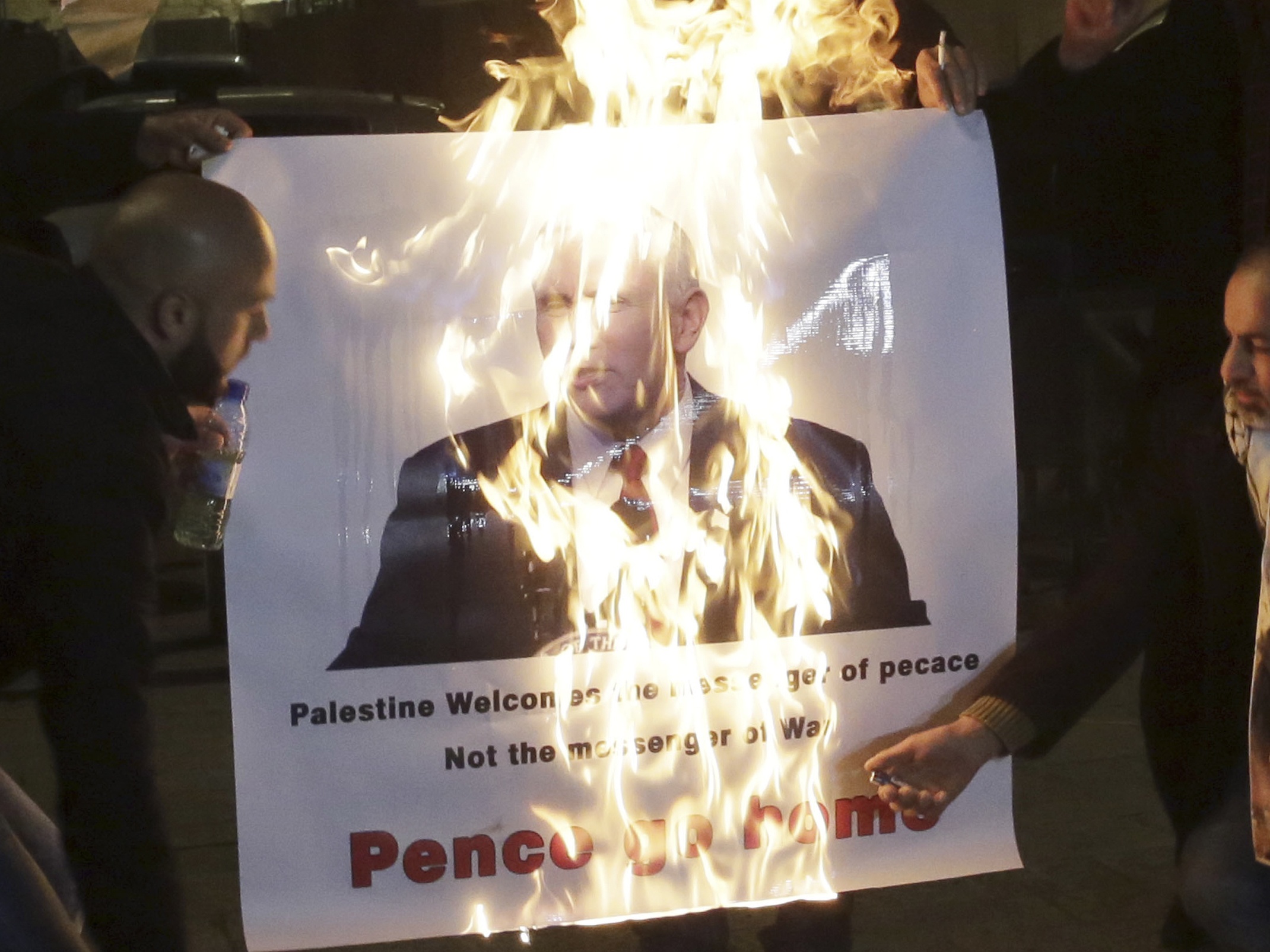 A picture of Mike Pence is burned by demonstrators (Mahmoud Illean /AP)
