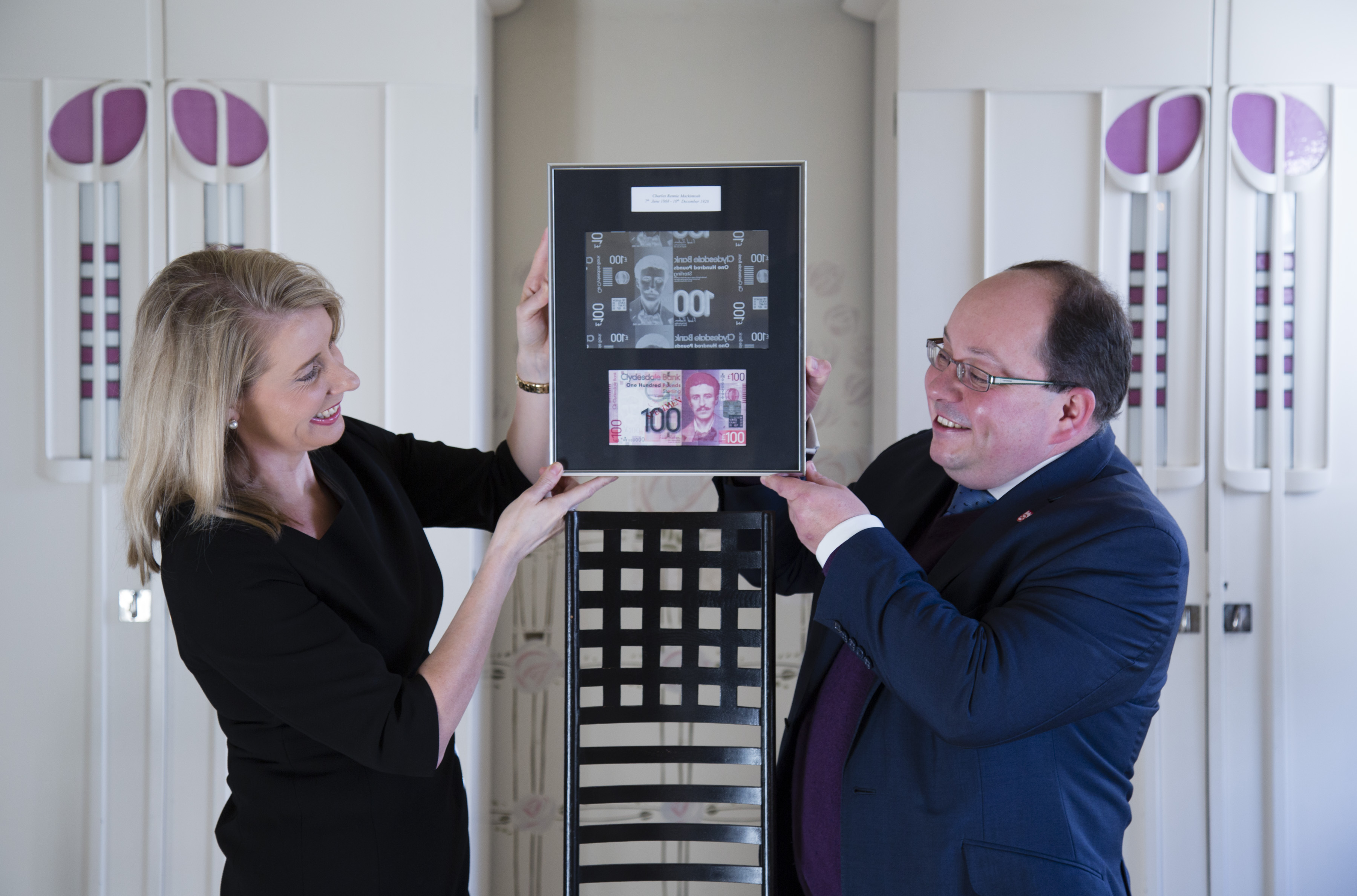Debbie Crosbie of The Clydesdale Bank and Richard Williams of The National Trust for Scotland with the £100 note at The Hill House (Martin Shields/National Trust for Scotland/PA)