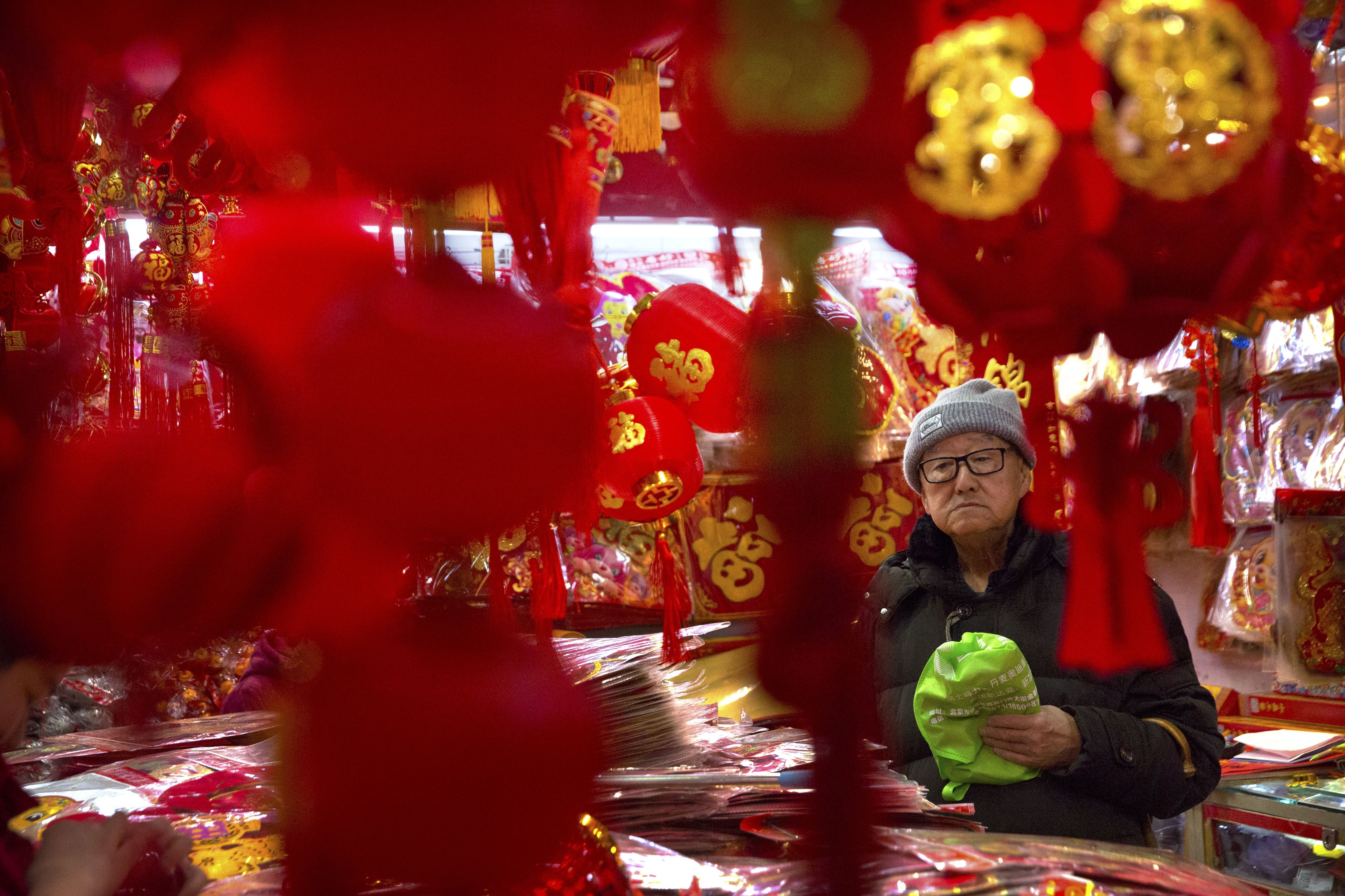A customer shops for Lunar New Year decorations at a wholesale market in Beijing (Mark Schiefelbein/AP)