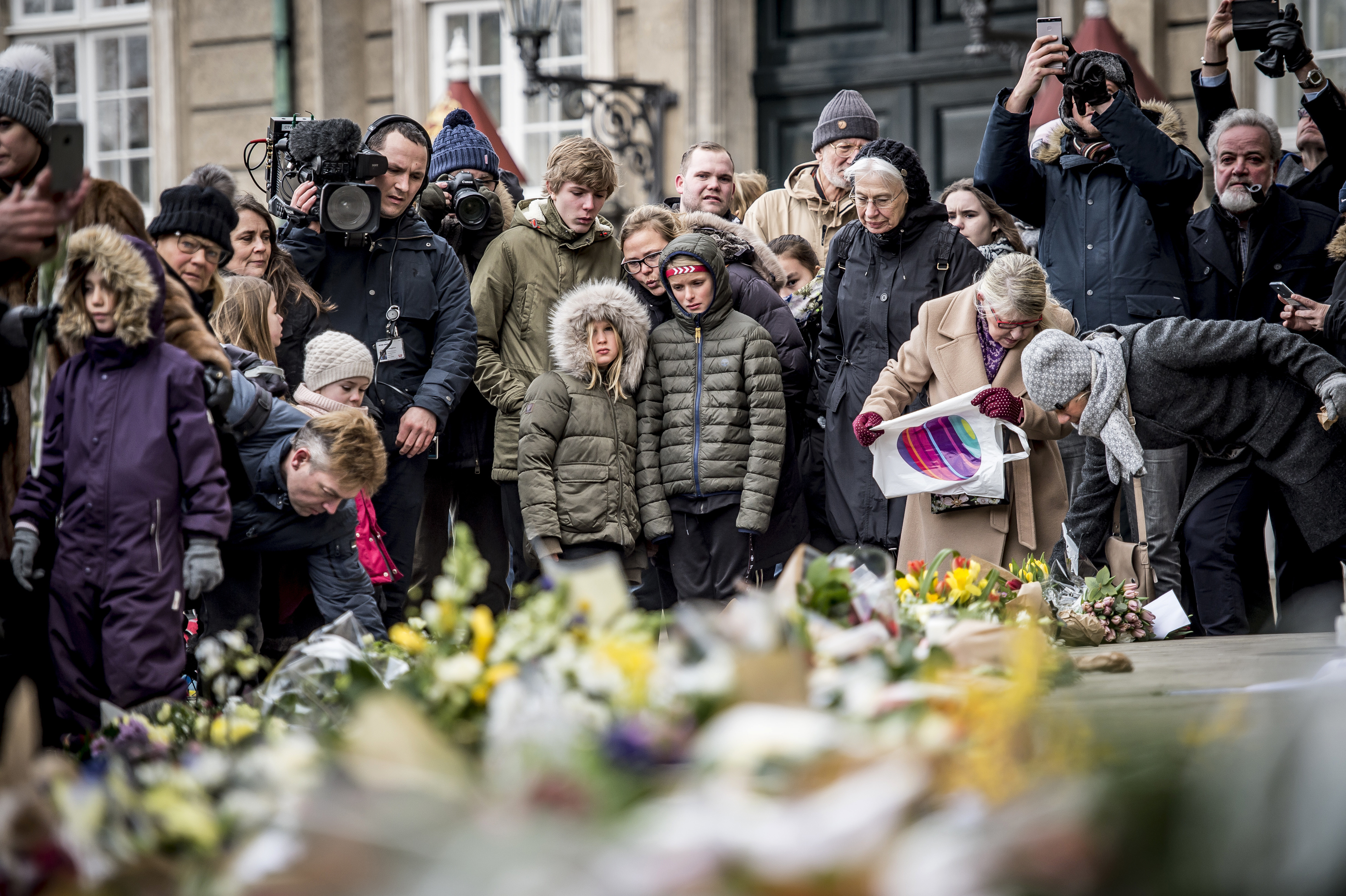 People gather to see and place floral tributes in front of the Amalienborg Palace in Copenhagen, Denmark (Mads Claus Rasmussen/Ritzau Scanpix via AP)