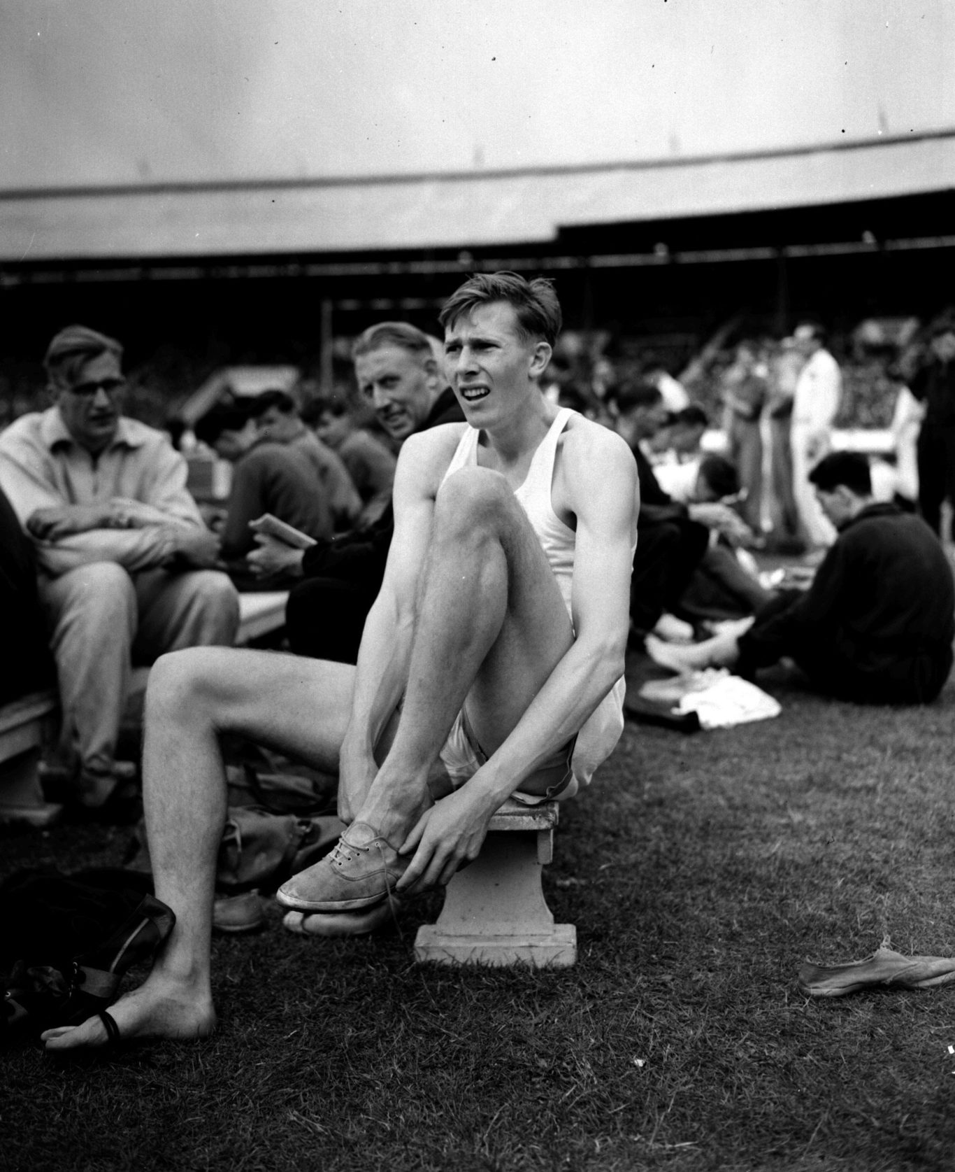 Roger Bannister changing his shoes during the AAA Championships at White City (PA)