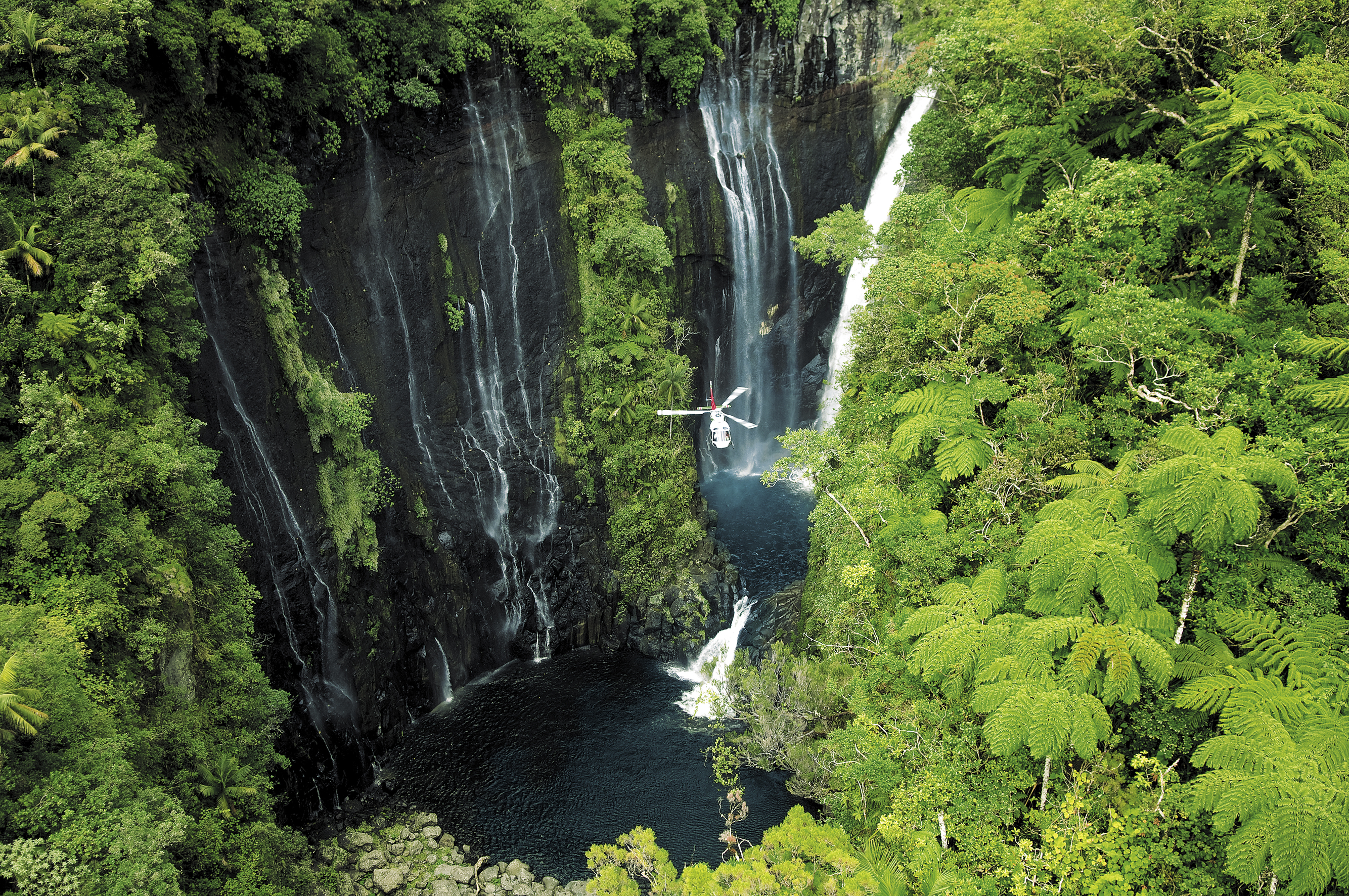 A helicopter flies past the Takamaka waterfalls on Reunion (Serge Gelabert/IRT/PA)