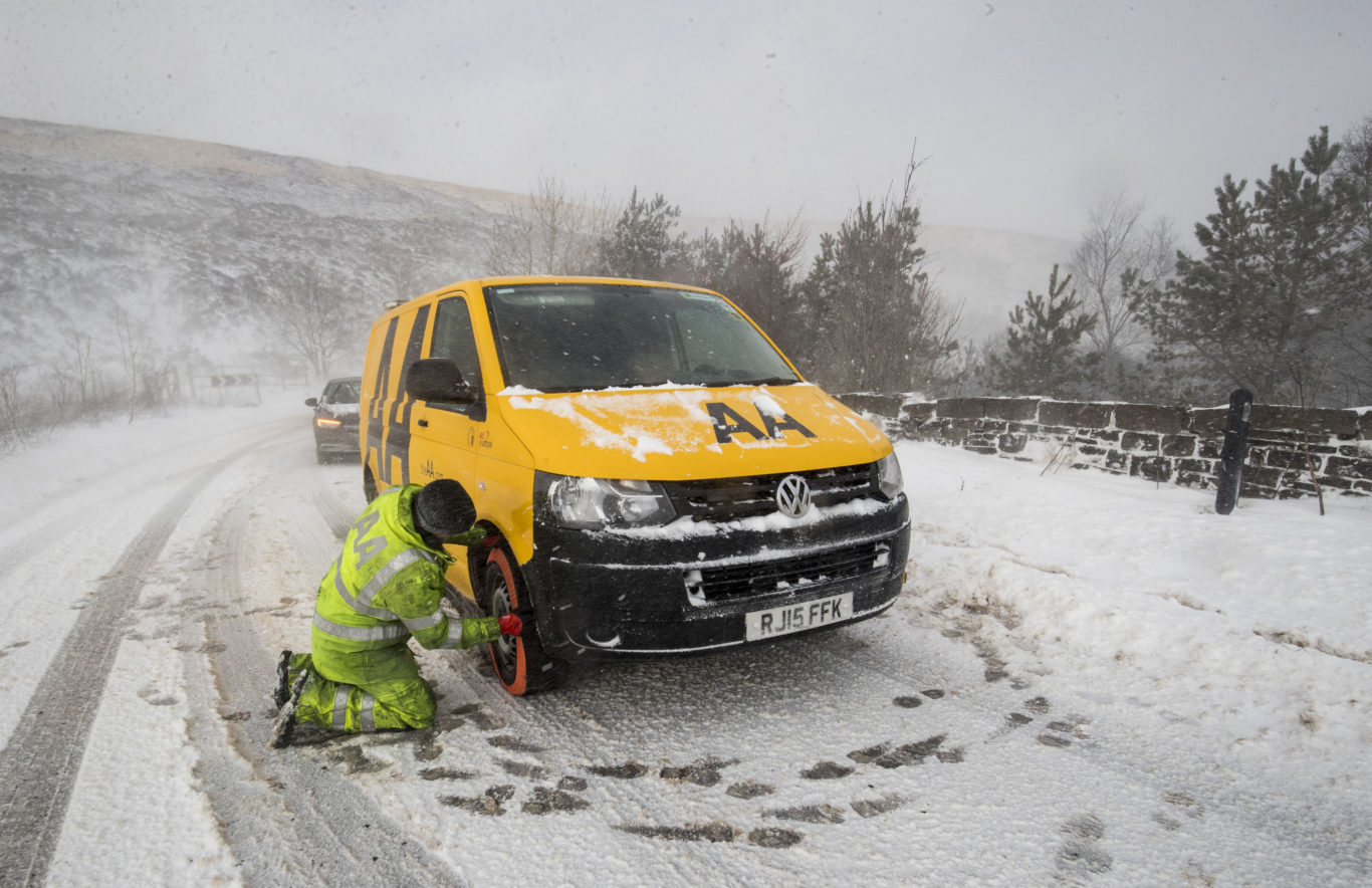 A man fits snow socks to an AA van near Denshaw in Greater Manchester (Danny Lawson/PA)