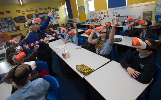 Pupils and their teacher at St John's Primary, Barrhead, test out the devices (ERC/PA)