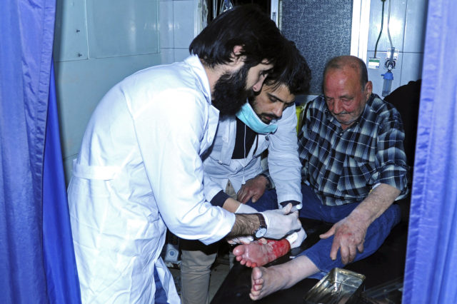 A man who was injured in the mortar attack receives treatment in hospital (SANA via AP)