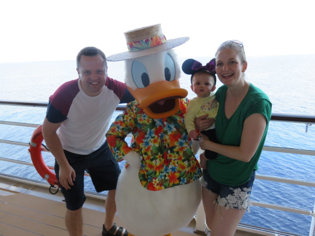 Wesley Johnson with his wife Carla and daughter Evie meet Donald Duck on the Disney Dream.