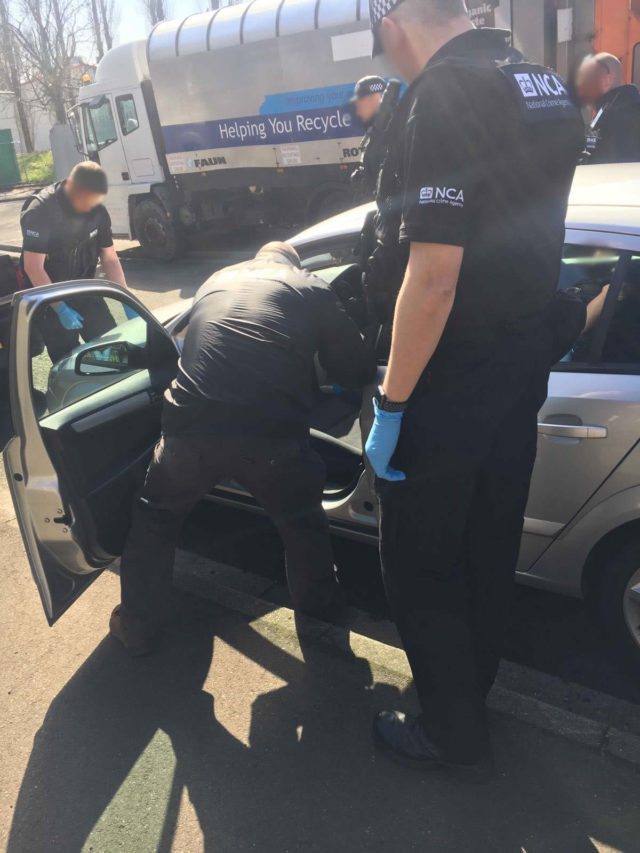 National Crime Agency (NCA) officers search a car in Oldham as part of an operation to tackle a people smuggling network (NCA/PA)