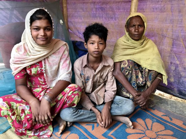 Selim Uddin, 12, with his older sister and his grandmother in their tent in the Balukhali refugee camp, Cox’s Bazar (Federica de Caria/PA)