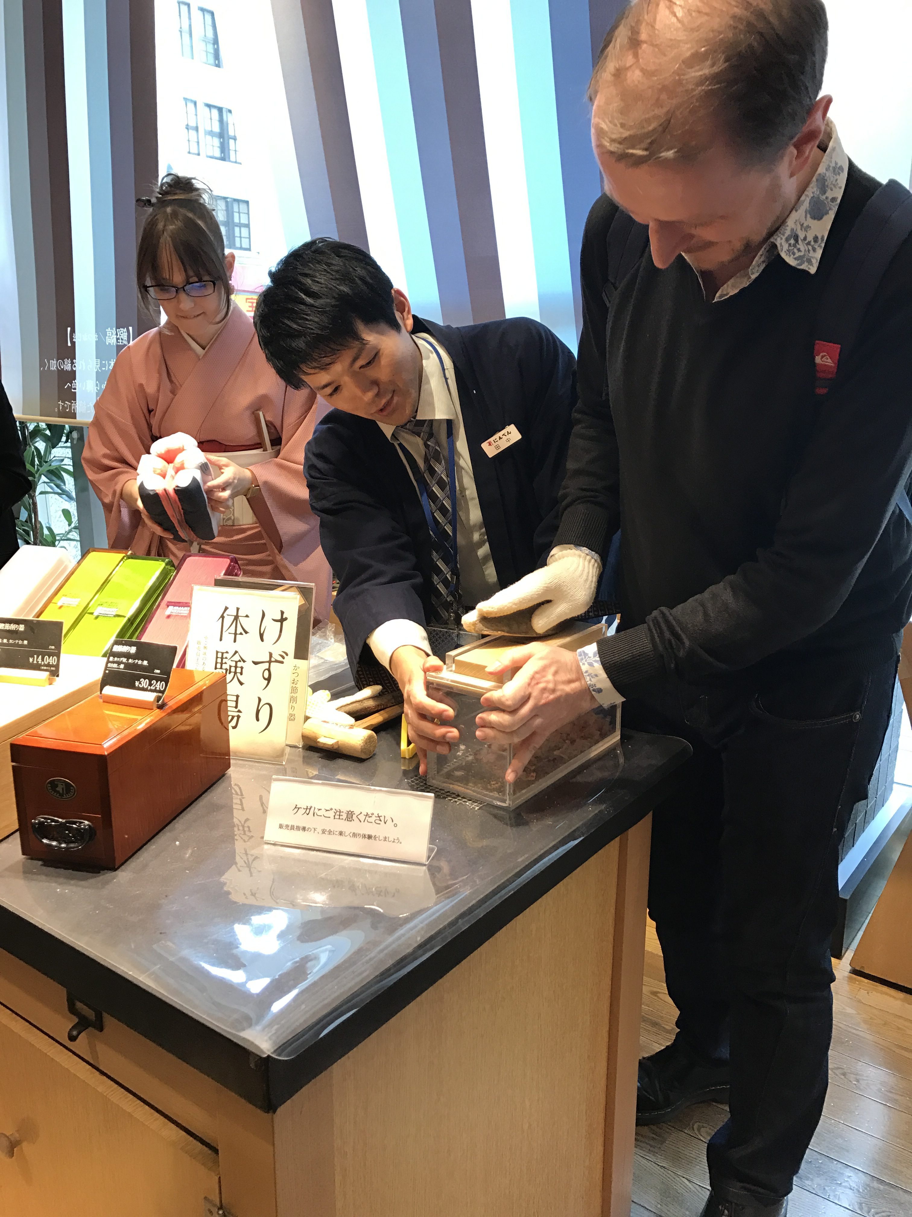 Damon Smith (left) attempts to make katsuobushi (shaven flakes of dried fish) in Ninben (Michiko Fujikawa/PA)