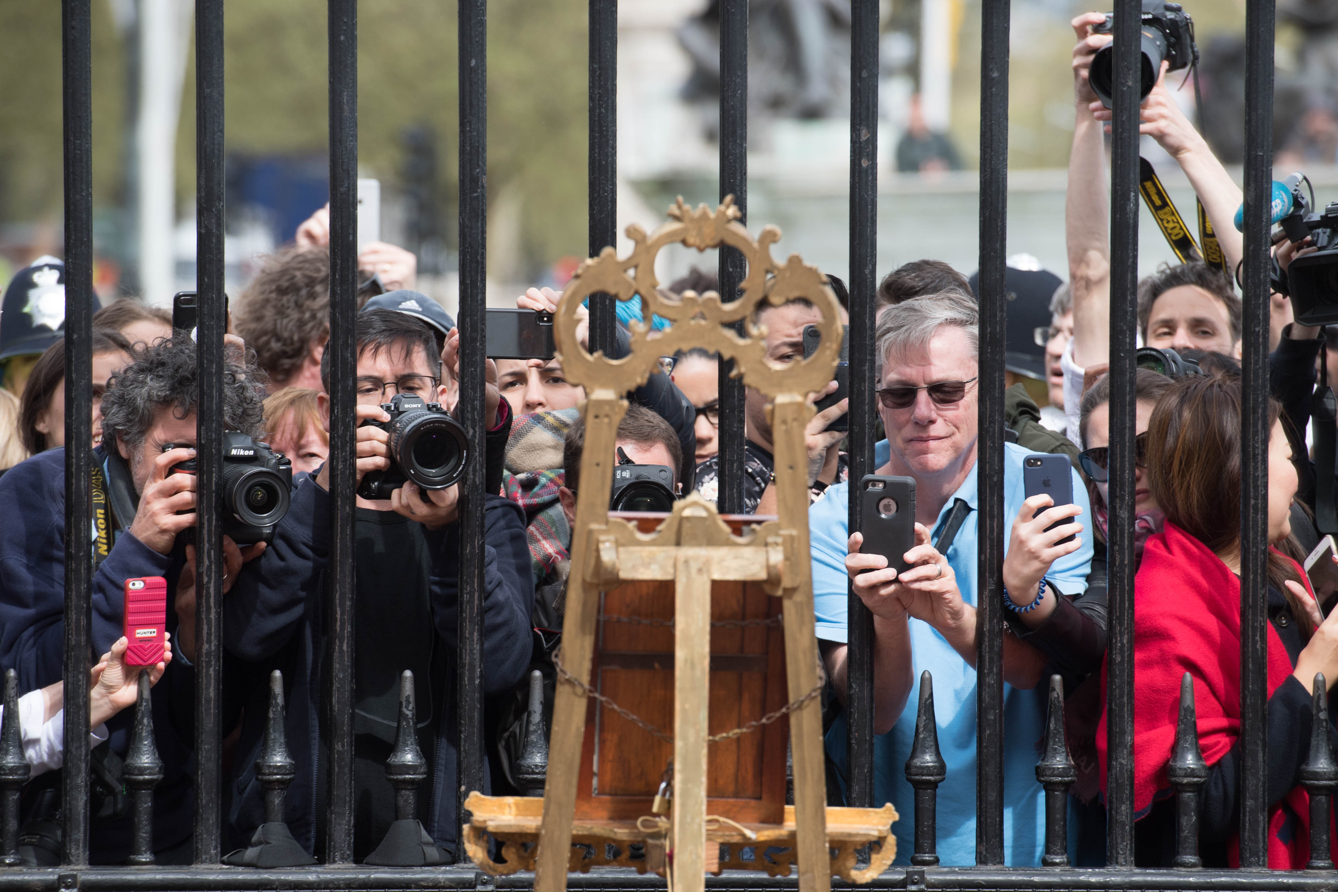 Tourists and photographers take pictures of a notice on an easel in the forecourt of Buckingham Palace in London to formally announce the birth of a baby boy to the Duke and Duchess of Cambridge at St Mary's Hospital