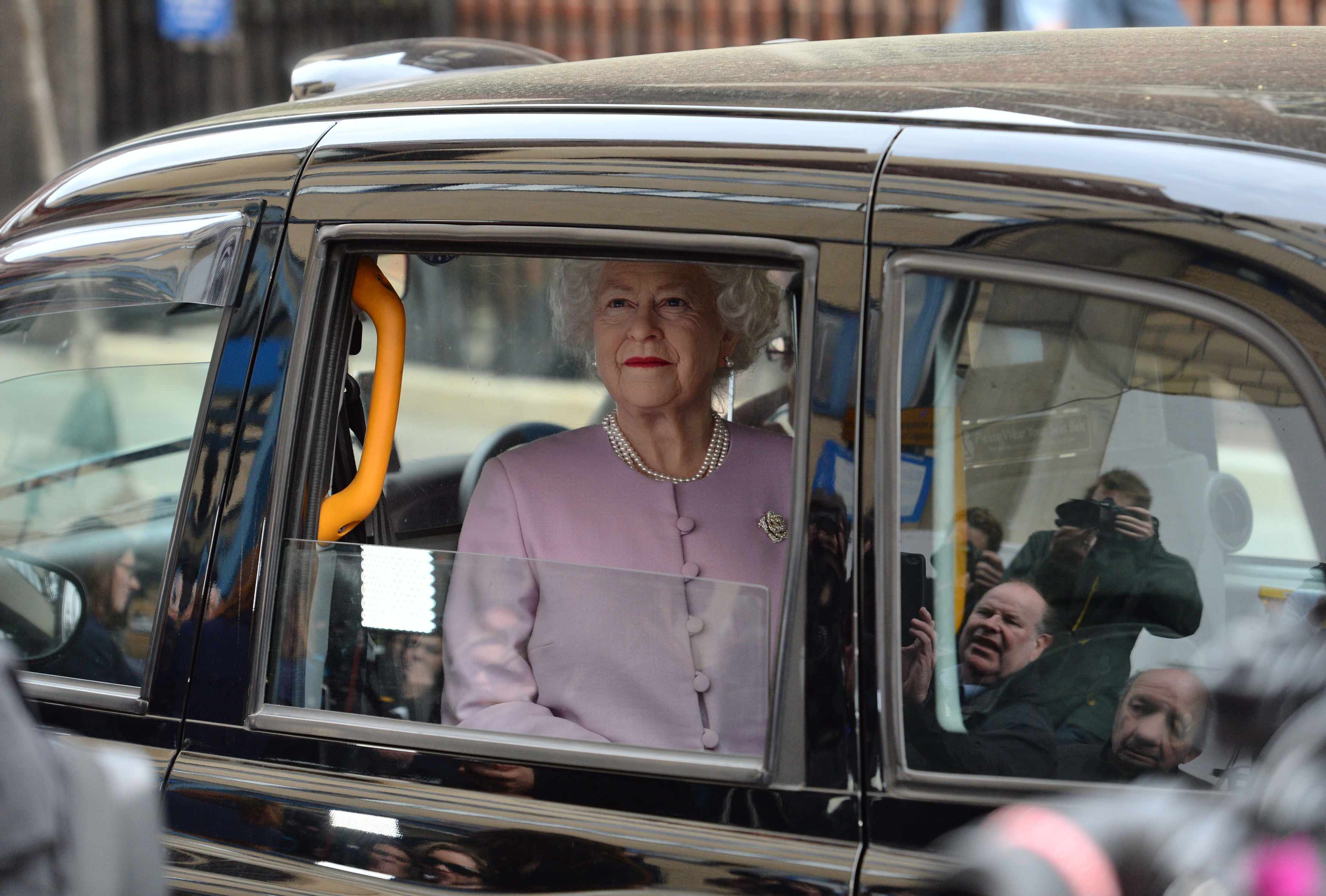 A waxwork of the Queen is driven past the Lindo Wing at St Mary's Hospital in Paddington in a taxi