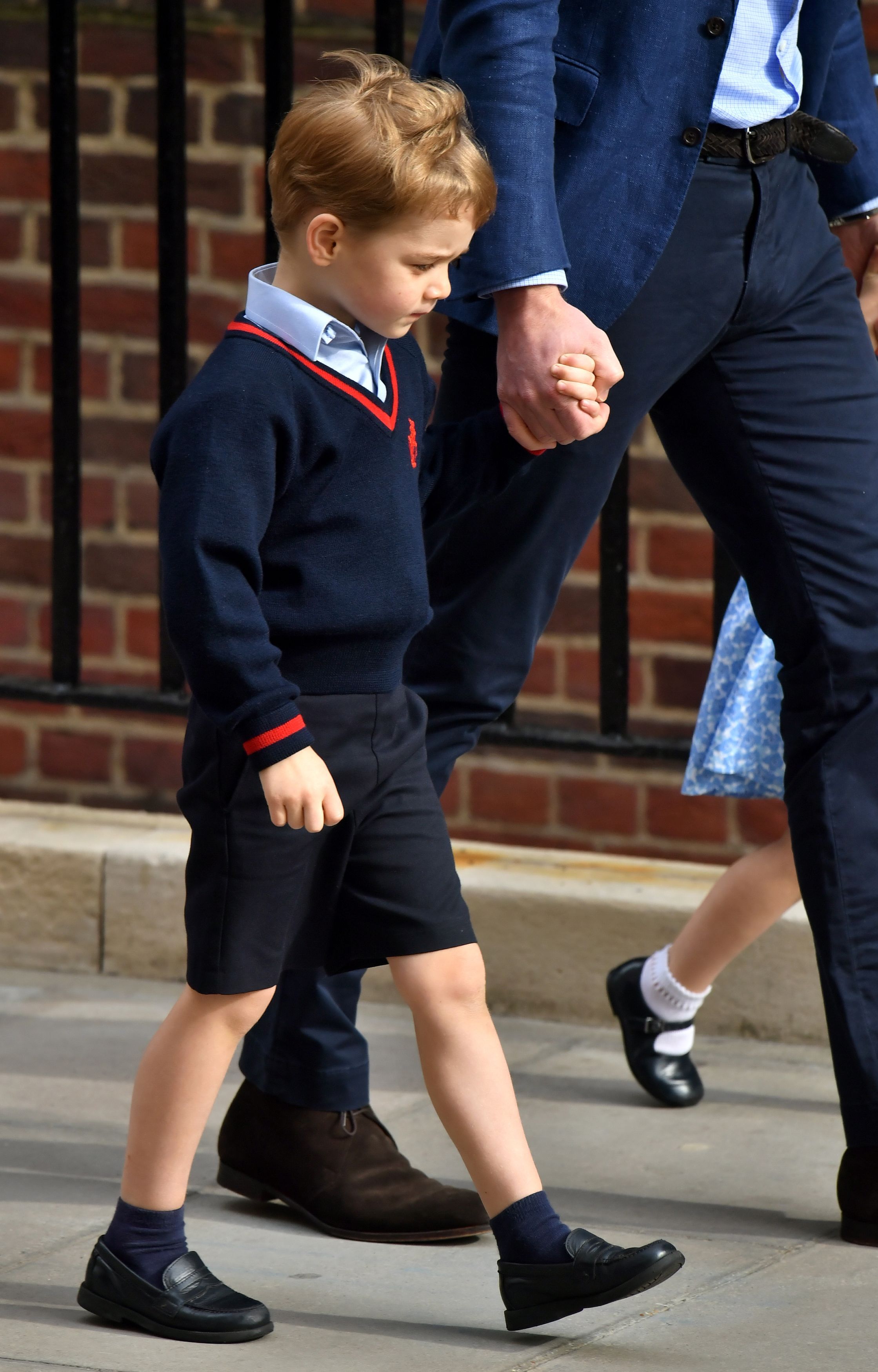 Prince George holds his father's hand as he arrives to meet his newborn brother at the Lindo Wing at St Mary's Hospital in Paddington, London