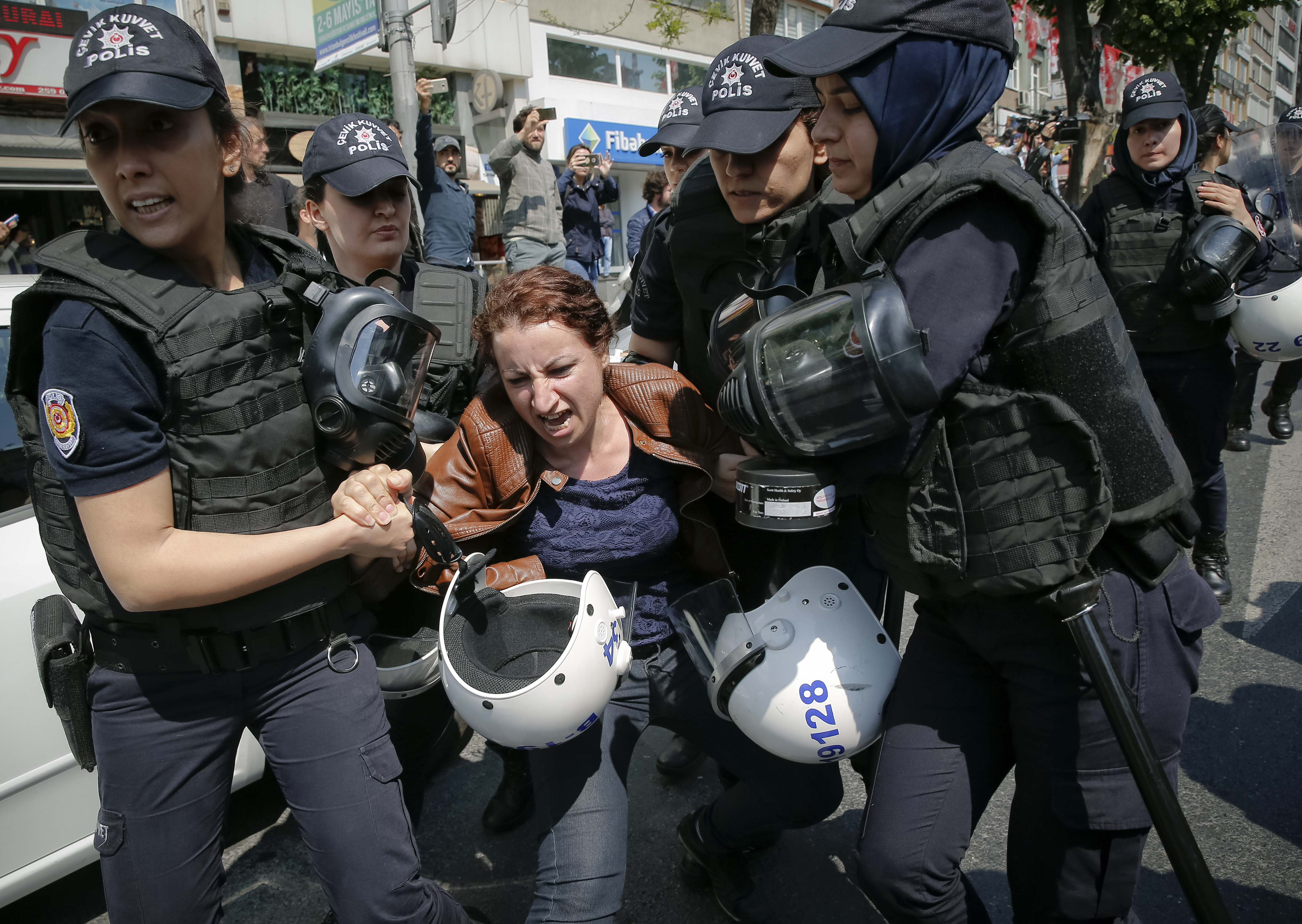 Police officers detain a woman taking part in May Day protests in Istanbul (Lefteris Pitarakis/AP)