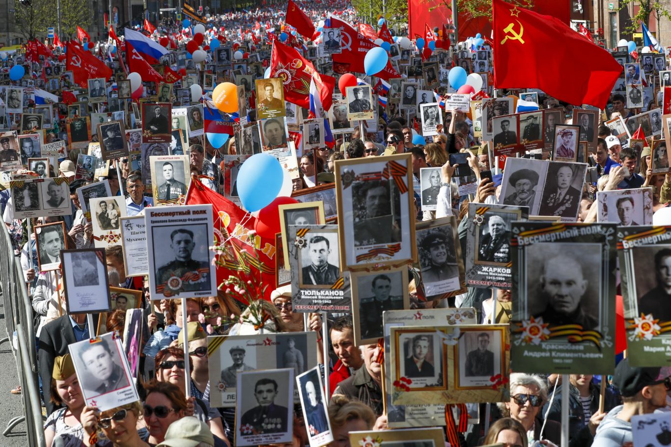 People carry portraits of relatives who fought during the Immortal Regiment march along Red Square in Moscow (AP)