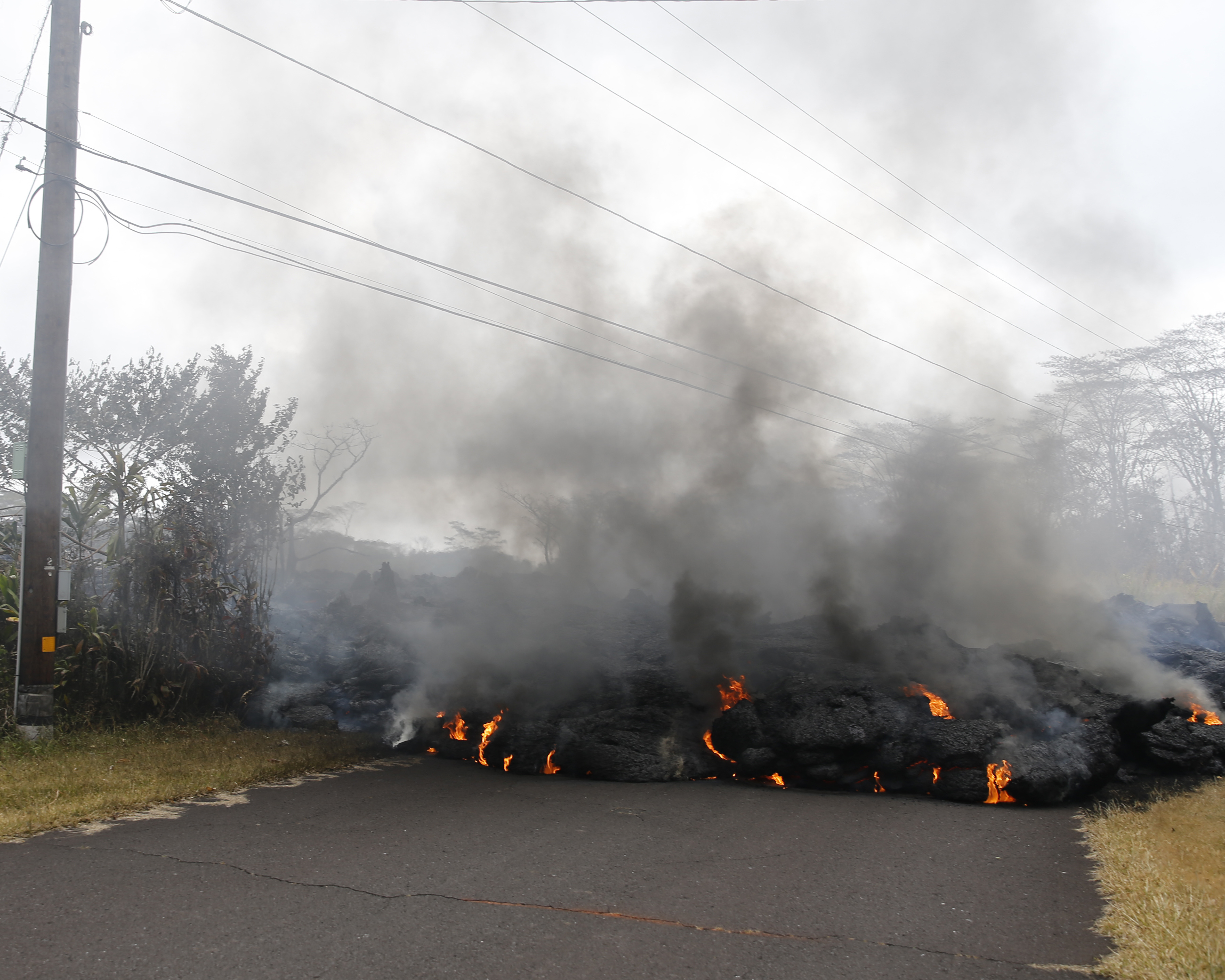 Lava crosses the road at Pohoiki Road near Pahoa, Hawaii (Marco Garcia/AP)