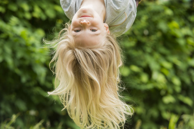 Girl upside -down playing outdoors
