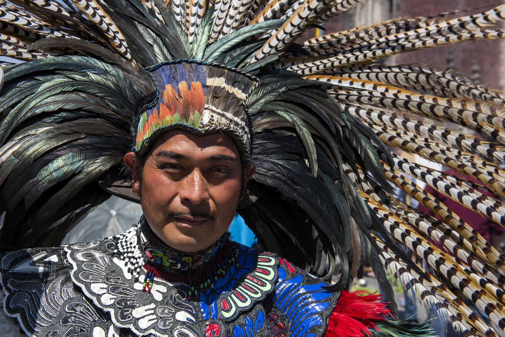 A dancer in indigenous dress performing on the streets of Mexico City (Renato Granieri/PA)