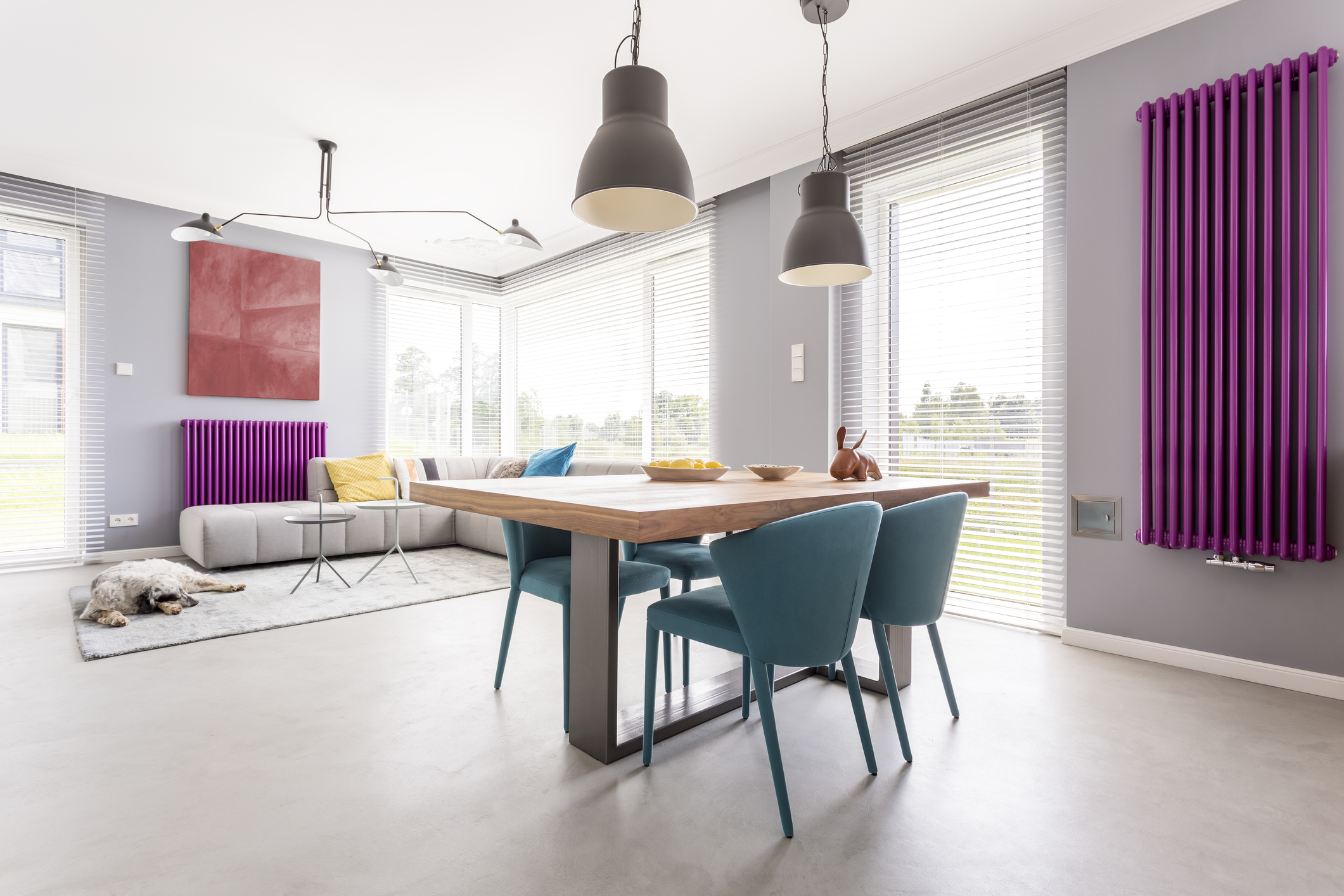 Trendy interior of dining area and open living room with big windows, artwork and colorful accessories