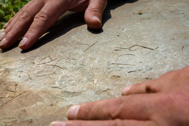 The stone's engraving includes Latin writing, Greek letters and Christian symbols (Christopher Ison/English Heritage/PA)