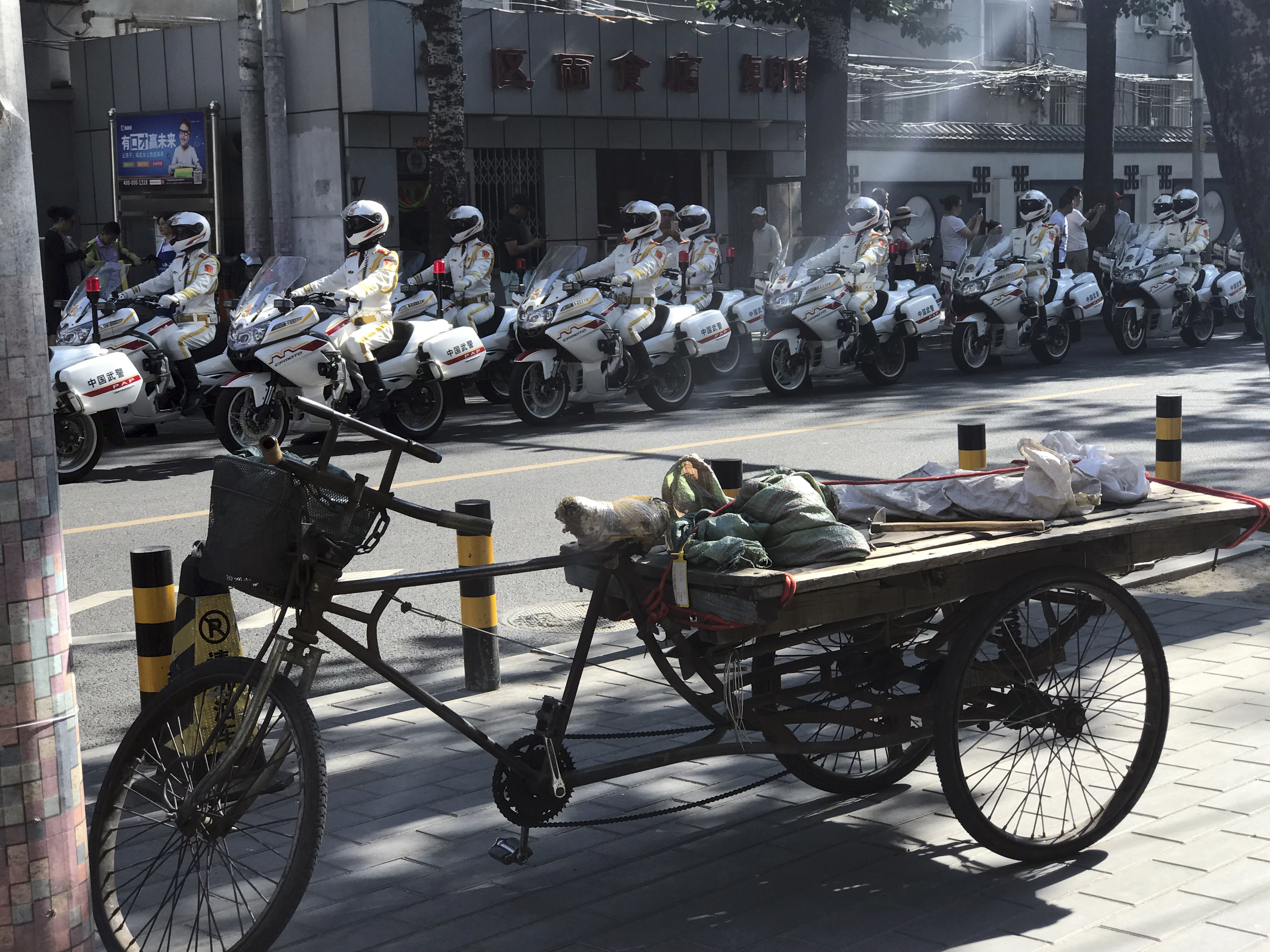 Police motorcycle escorts wait for Kim Jong Un's motorcad