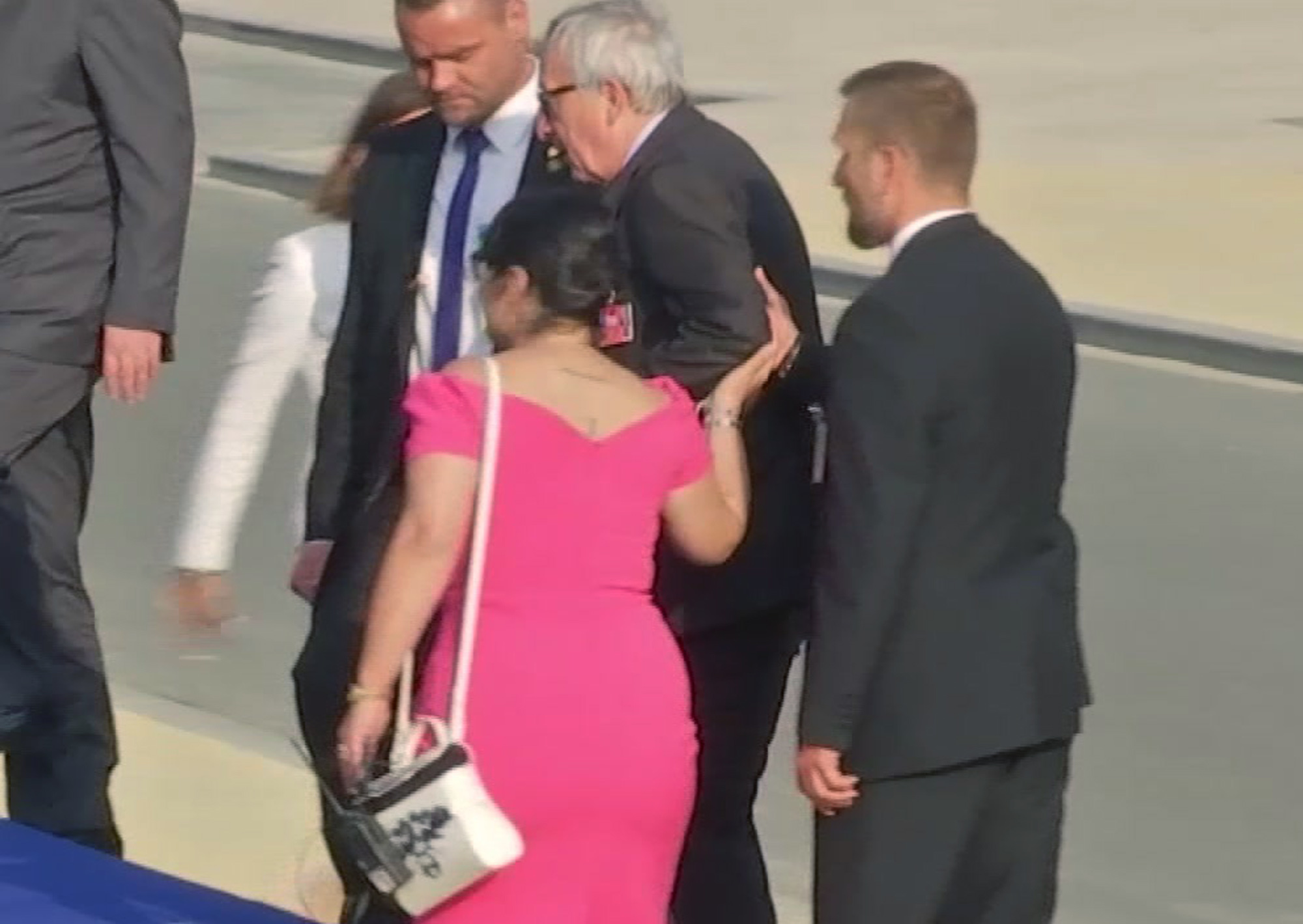 Jean-Claude Juncker is helped up the stairs at Parc Cinquantenaire in Brussels