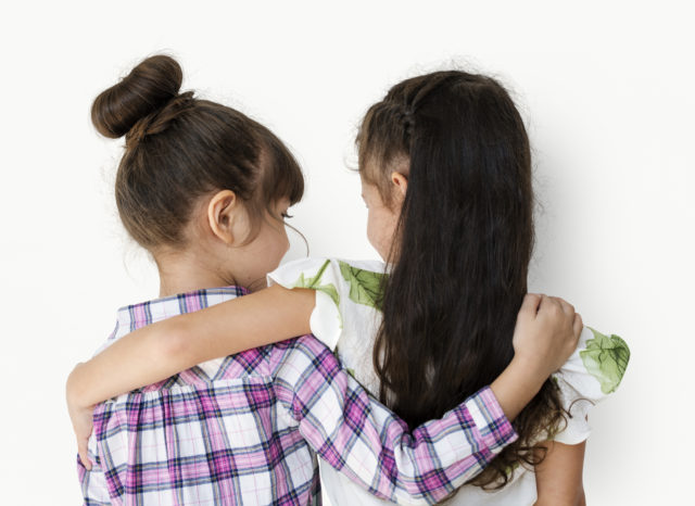 Girls with arms around each other rear view