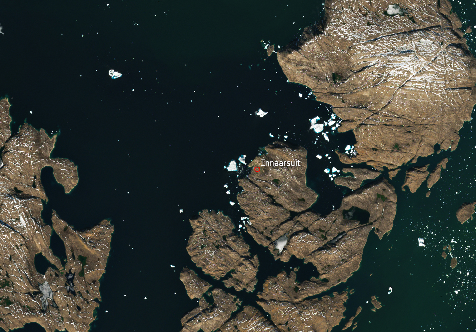 A satellite image shows a huge iceberg perilously close to the village of Innaarsuit