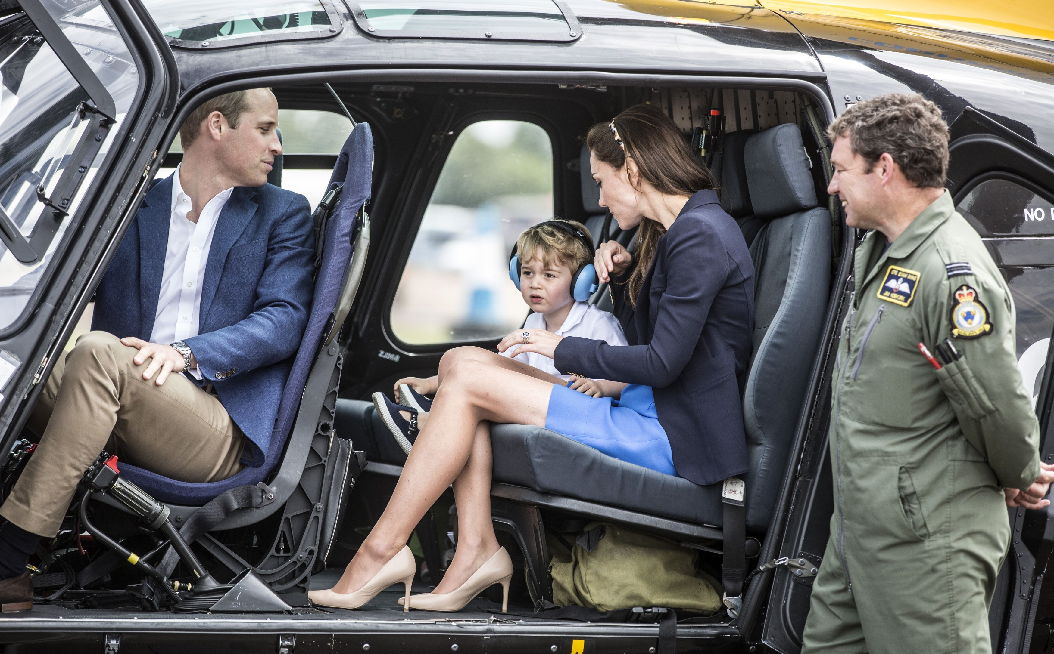 Prince George sits in a Squirrel helicopter with his parents the Duke and Duchess of Cambridge during a visit to the Royal International Air Tattoo at RAF Fairford - the world's largest military airshow 