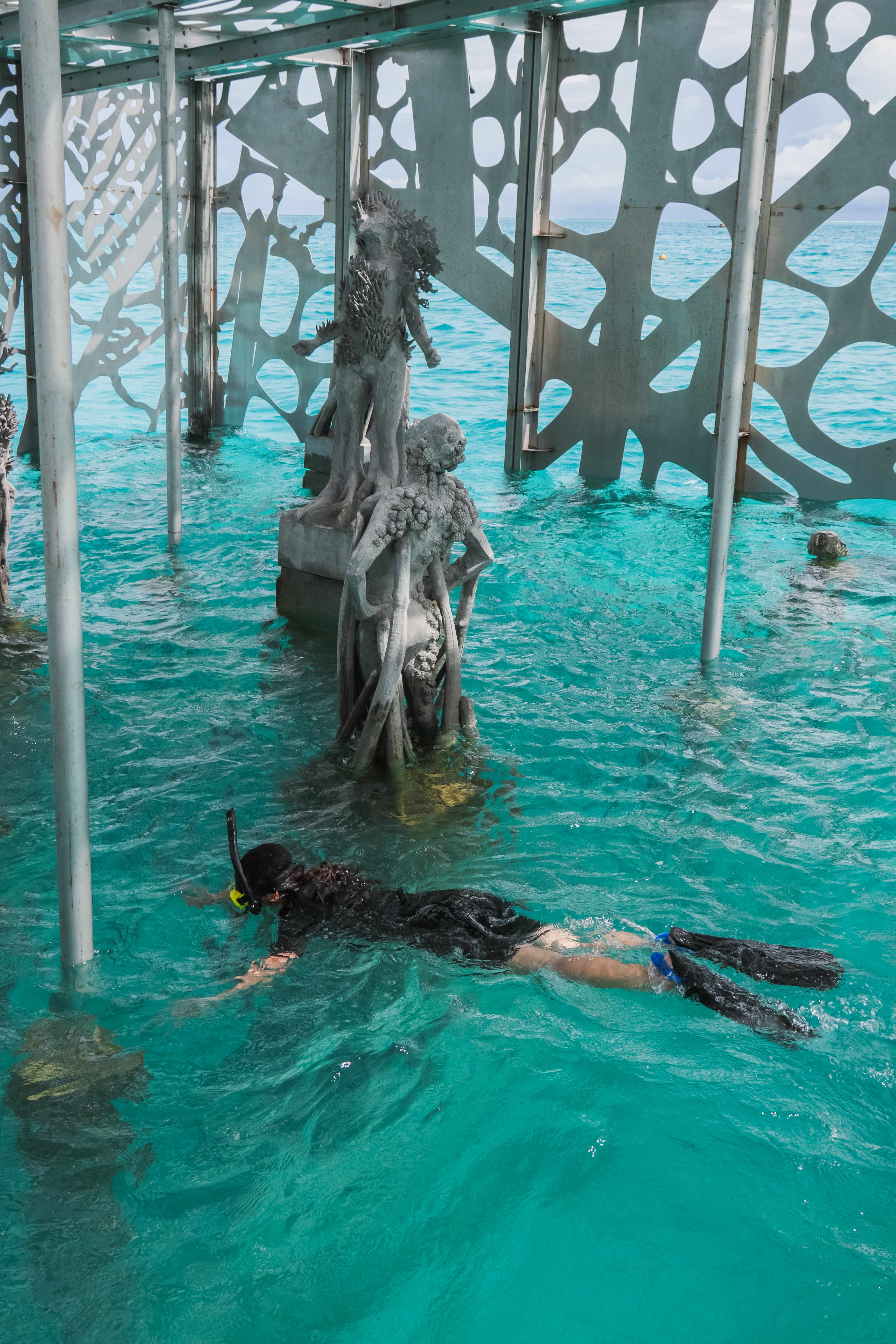 A snorkeller admiring semi-submerged artwork