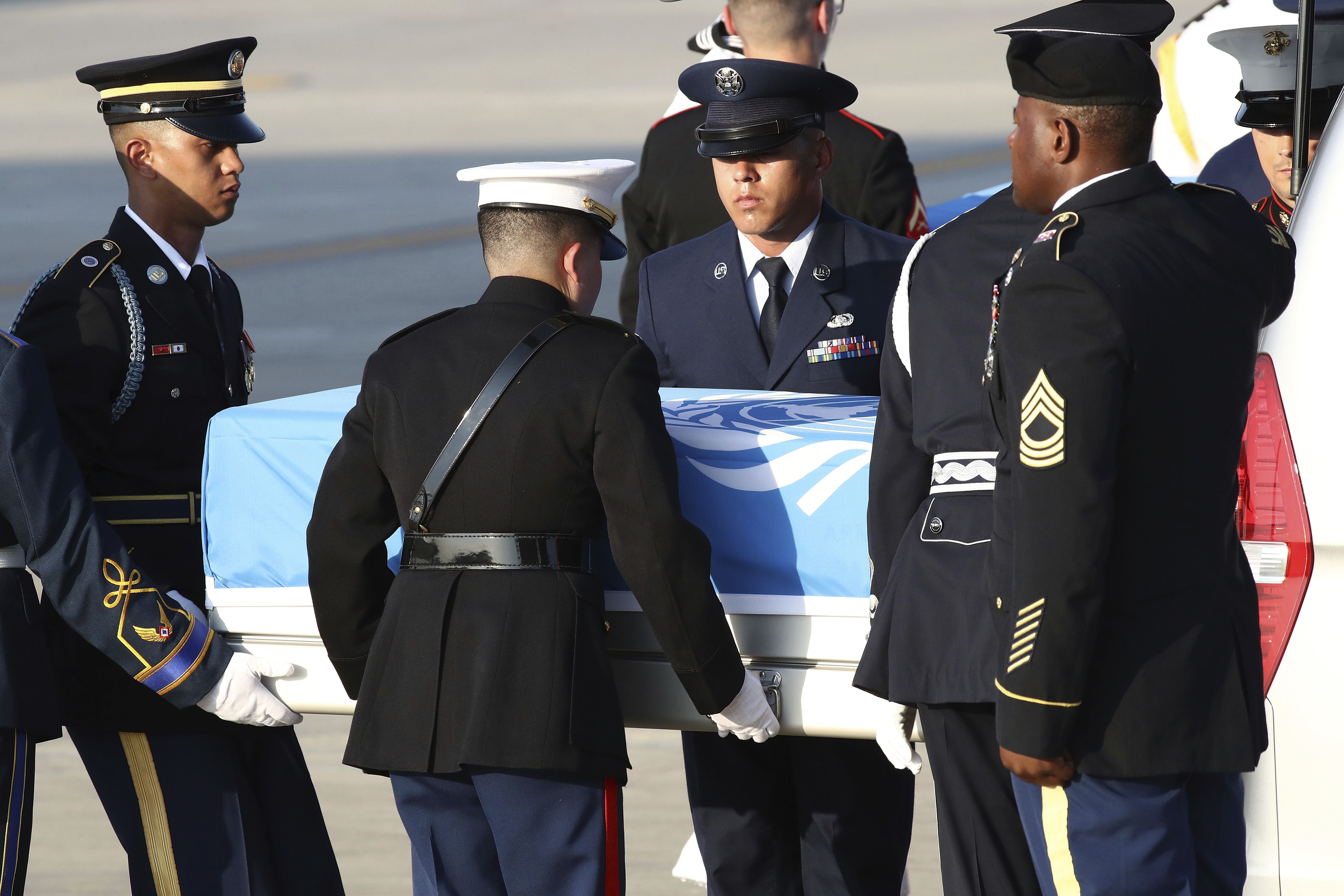 Honour guards carry the remains of US servicemen killed in the Korean War
