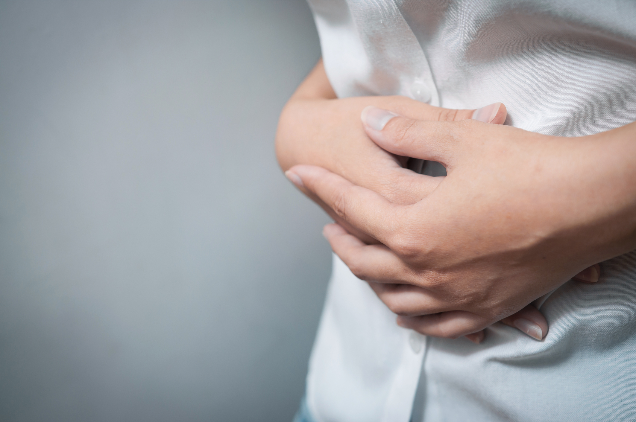Closeup of hands of woman have a stomachache. Menstruation of women. Concept of a woman need to go to the toilet.