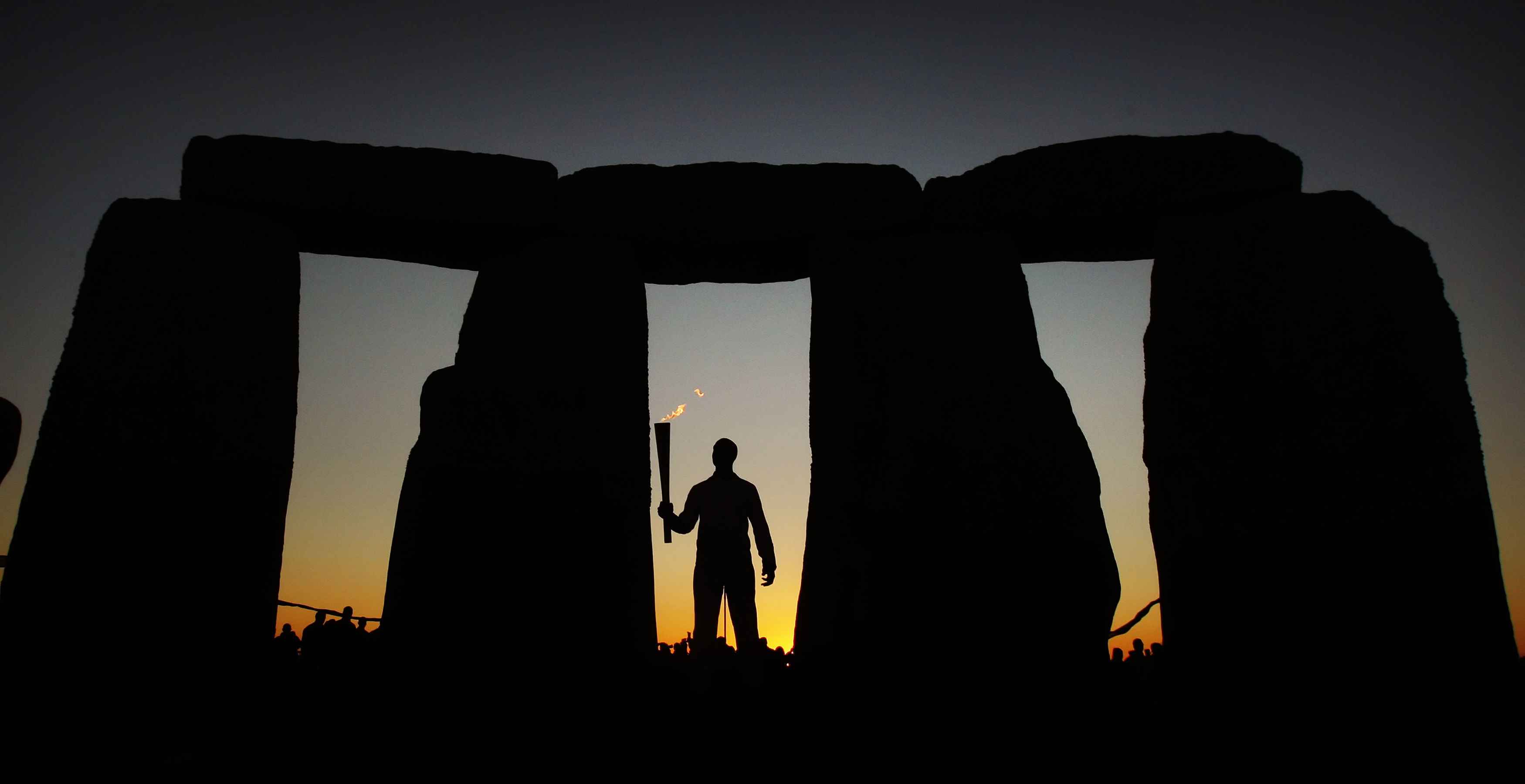 Michael Johnson holding the Olympic Flame at Stonehenge in 2012