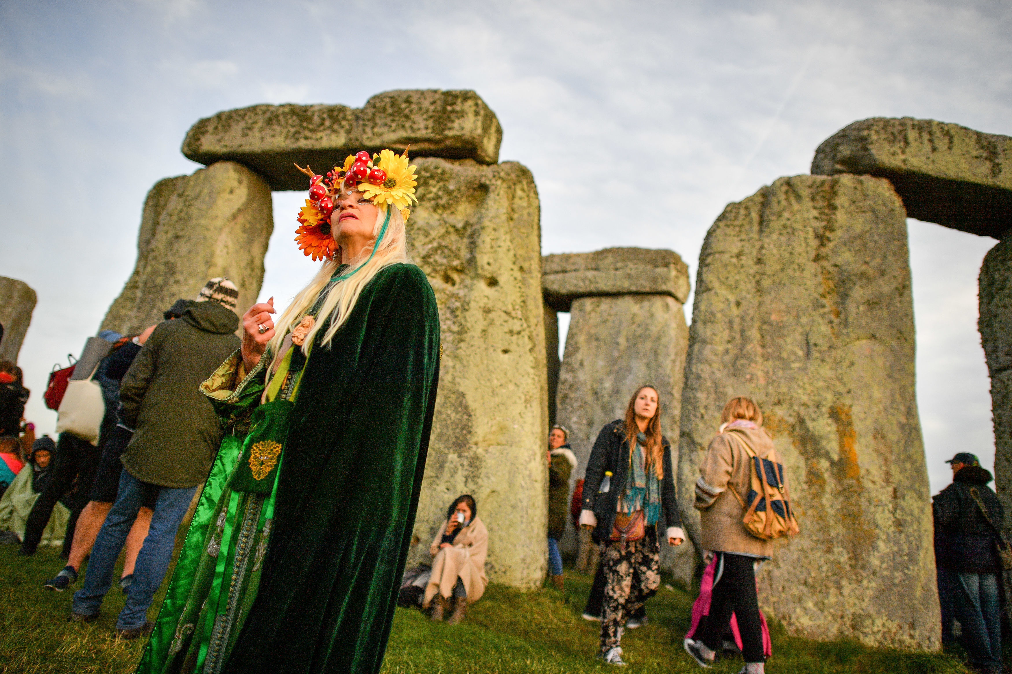 A woman wearing a colourful head-dress at Stonehenge during the 2018 Summer Solstice