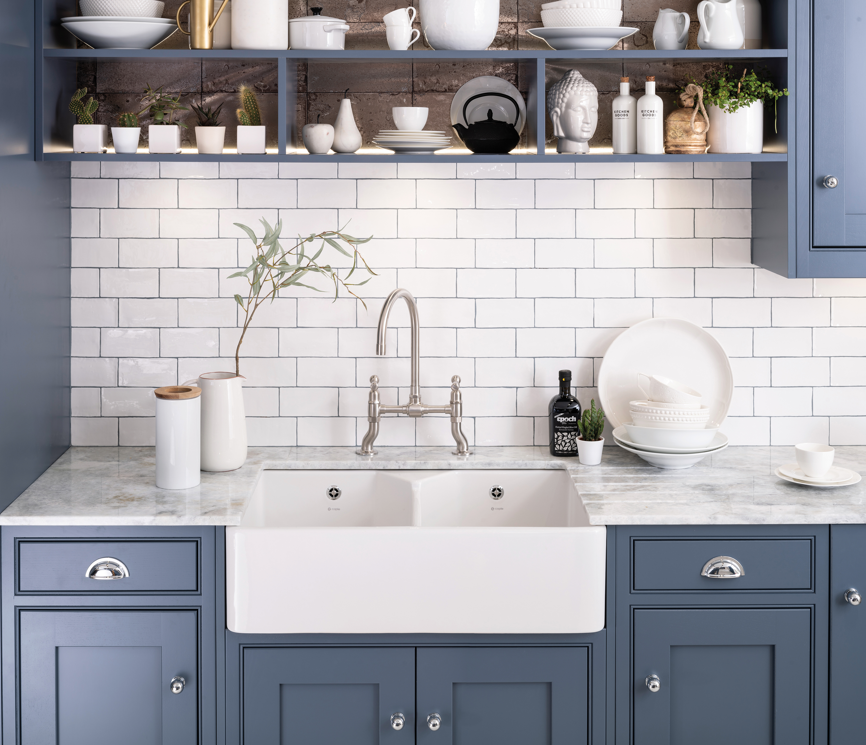 Caple's stainless steel Putney Bridge tap, from around £330 (shown here with a Chepstow sink in a Harptree kitchen), features a classic dual flow bridge design and ceramic valves (Caple/PA)