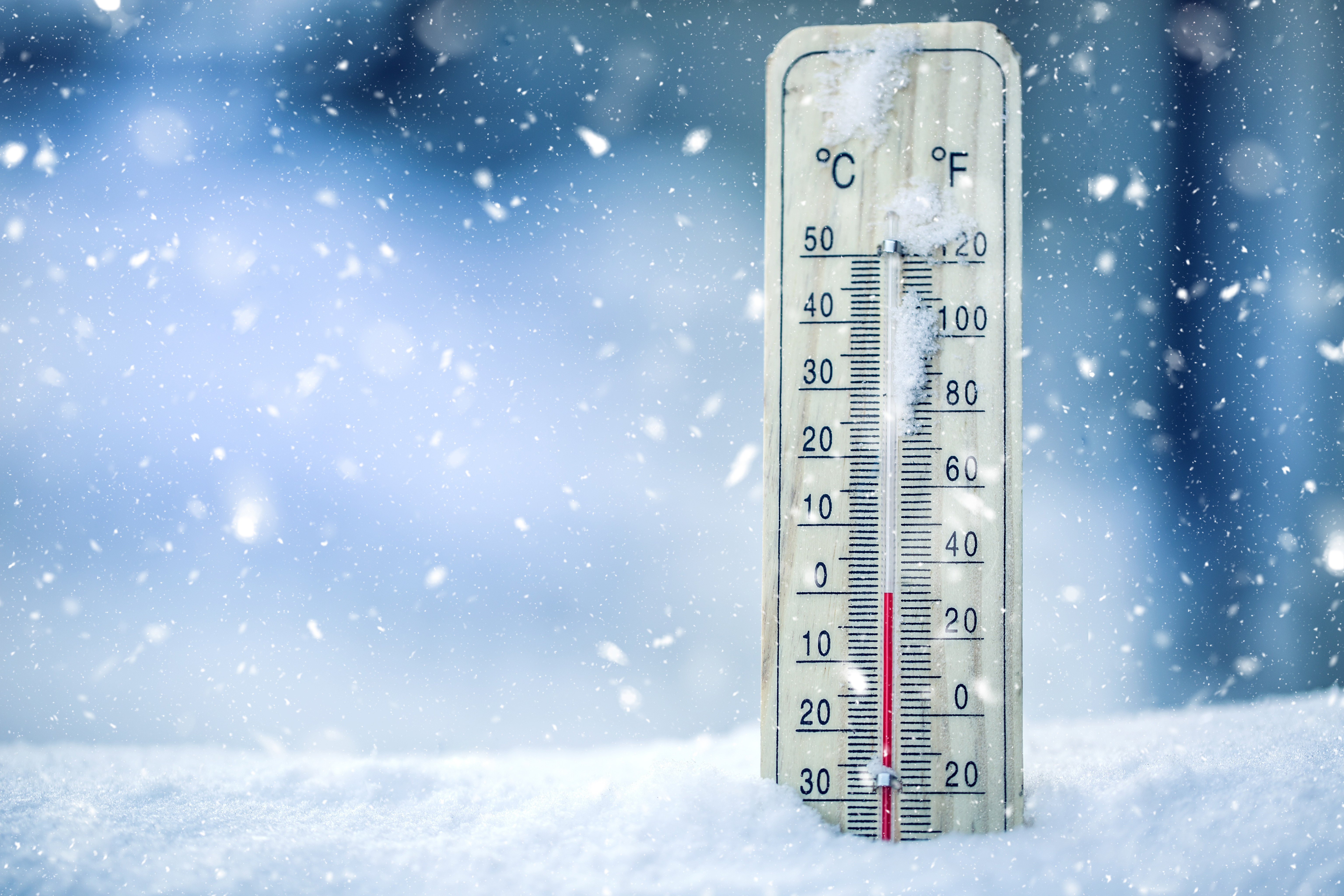 A thermometer surrounded by frost and snow