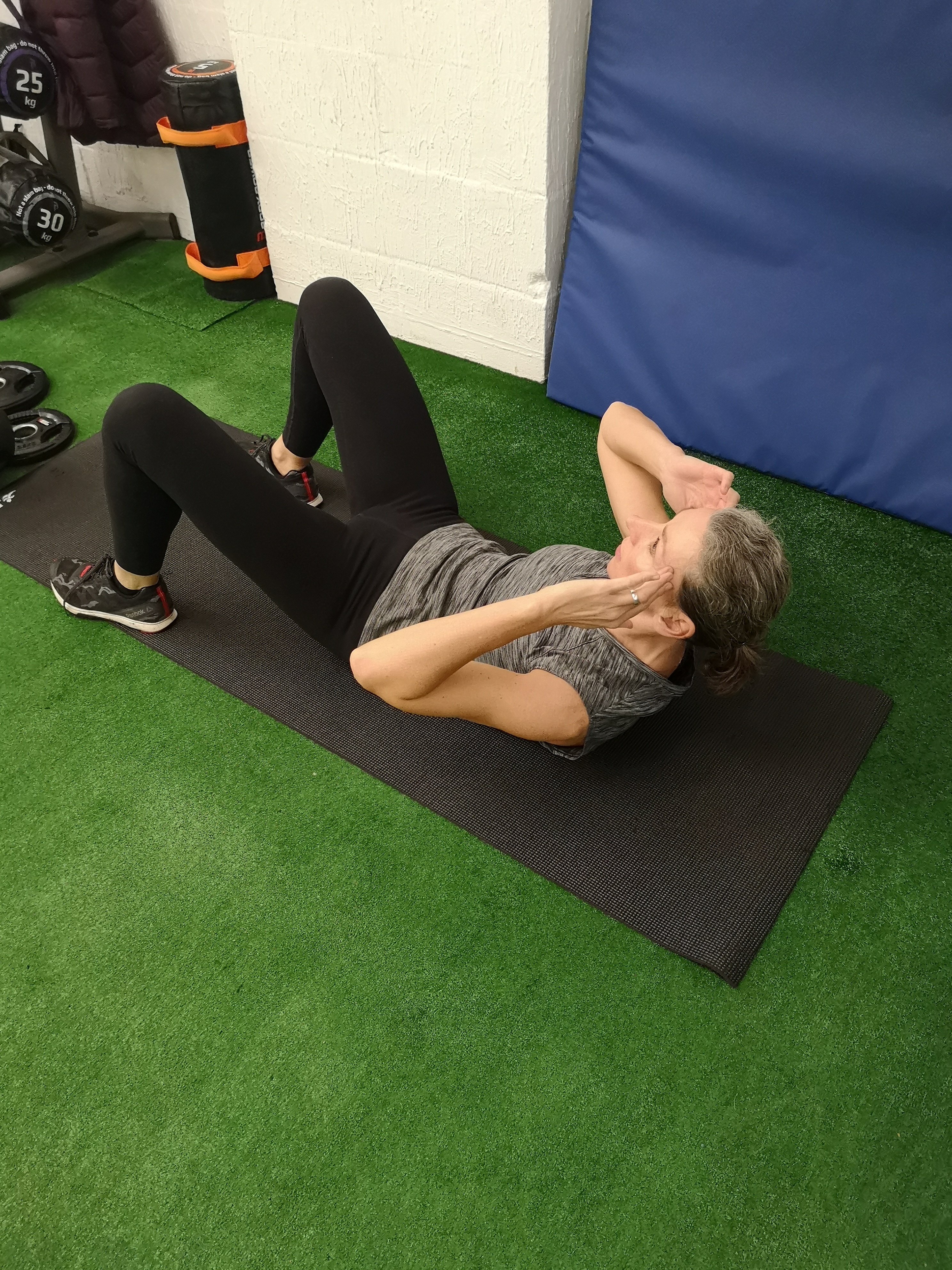 A woman performs an abdominal crunch (Chris O'Rourke/PA)