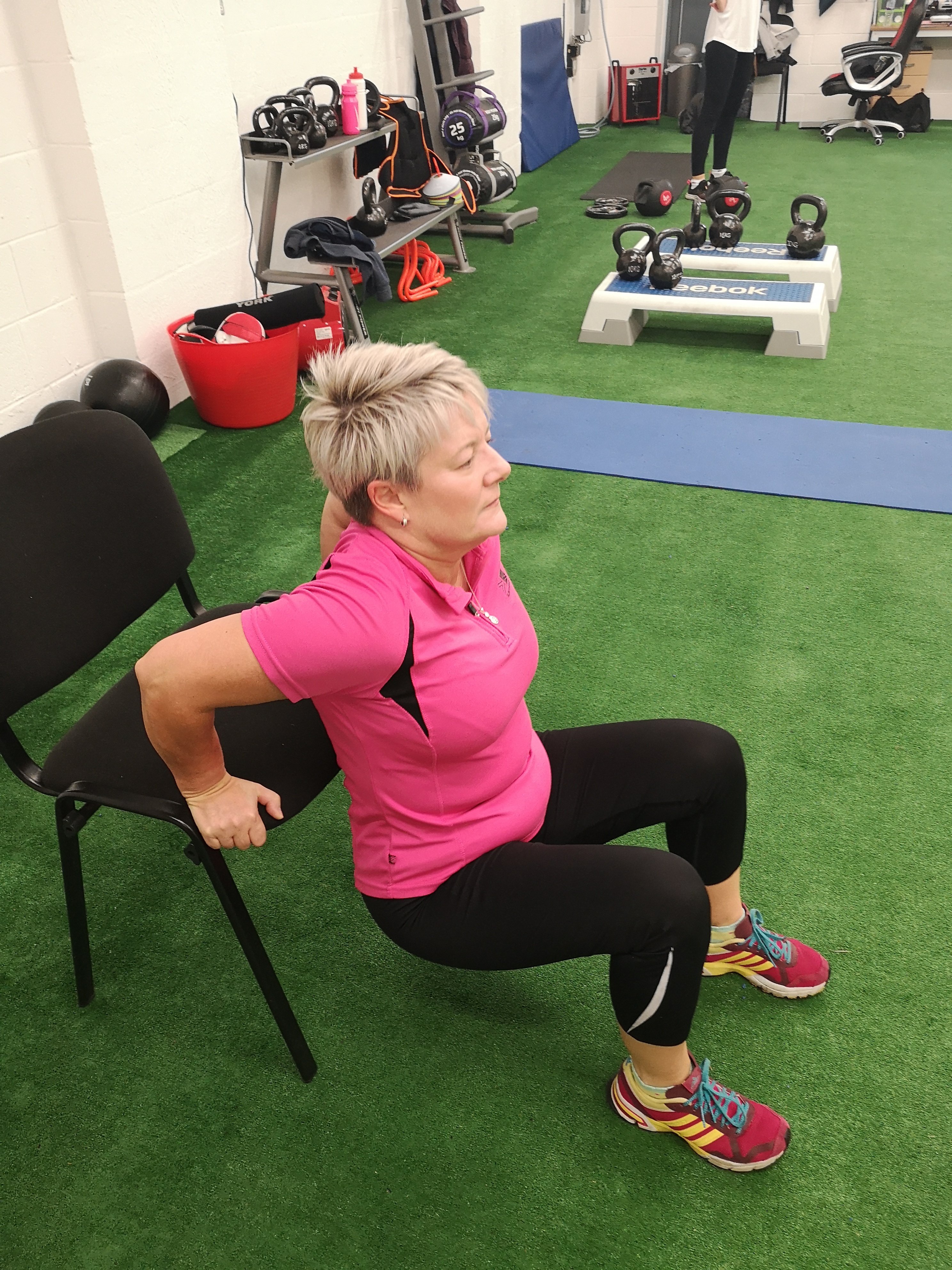 A woman performs tricep dips (Chris O'Rourke/PA)